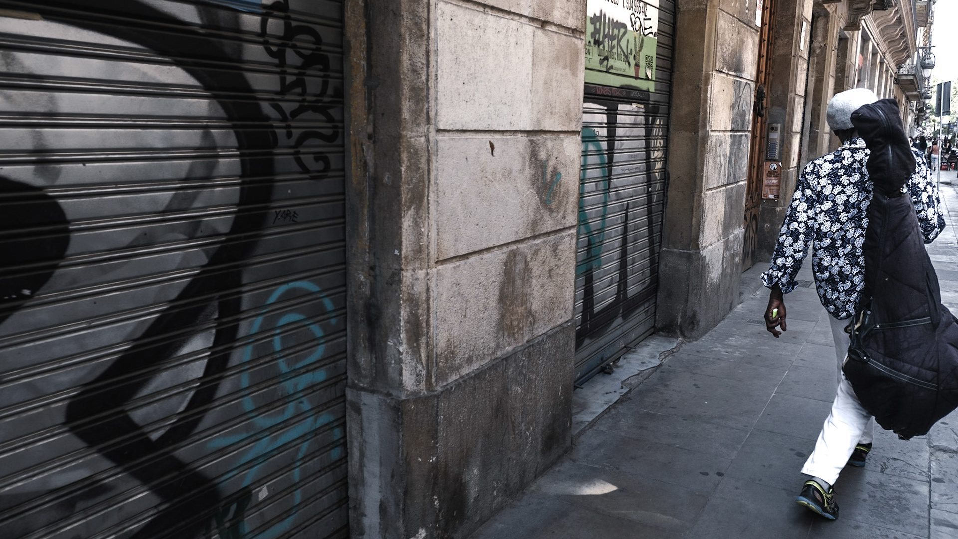 A musician walks on a street in El Born barrio in Barcelona