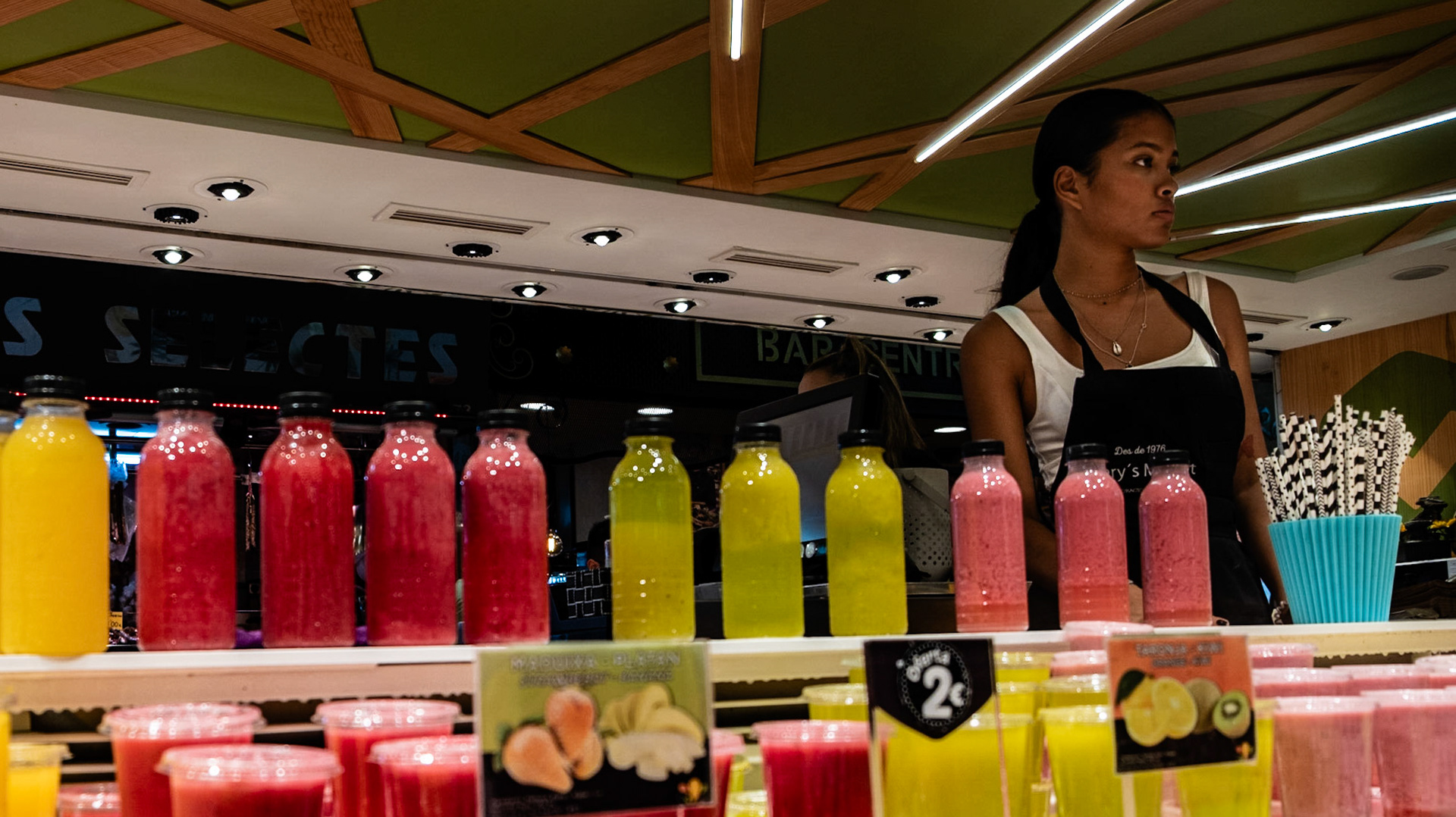 A woman sells a variety of freshly squeezed juices in the La Boqueria Market in La Rambla Barcelona