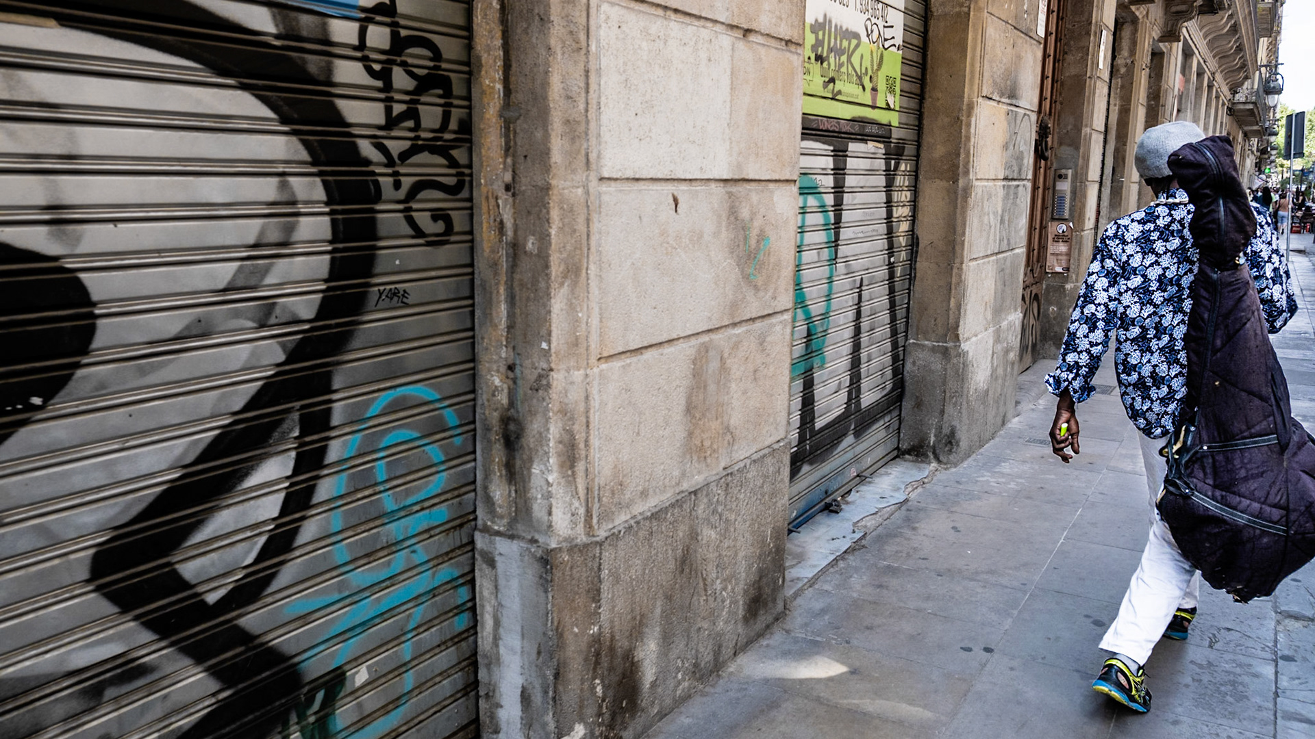 A musician walks on a street in El Born barrio in Barcelona