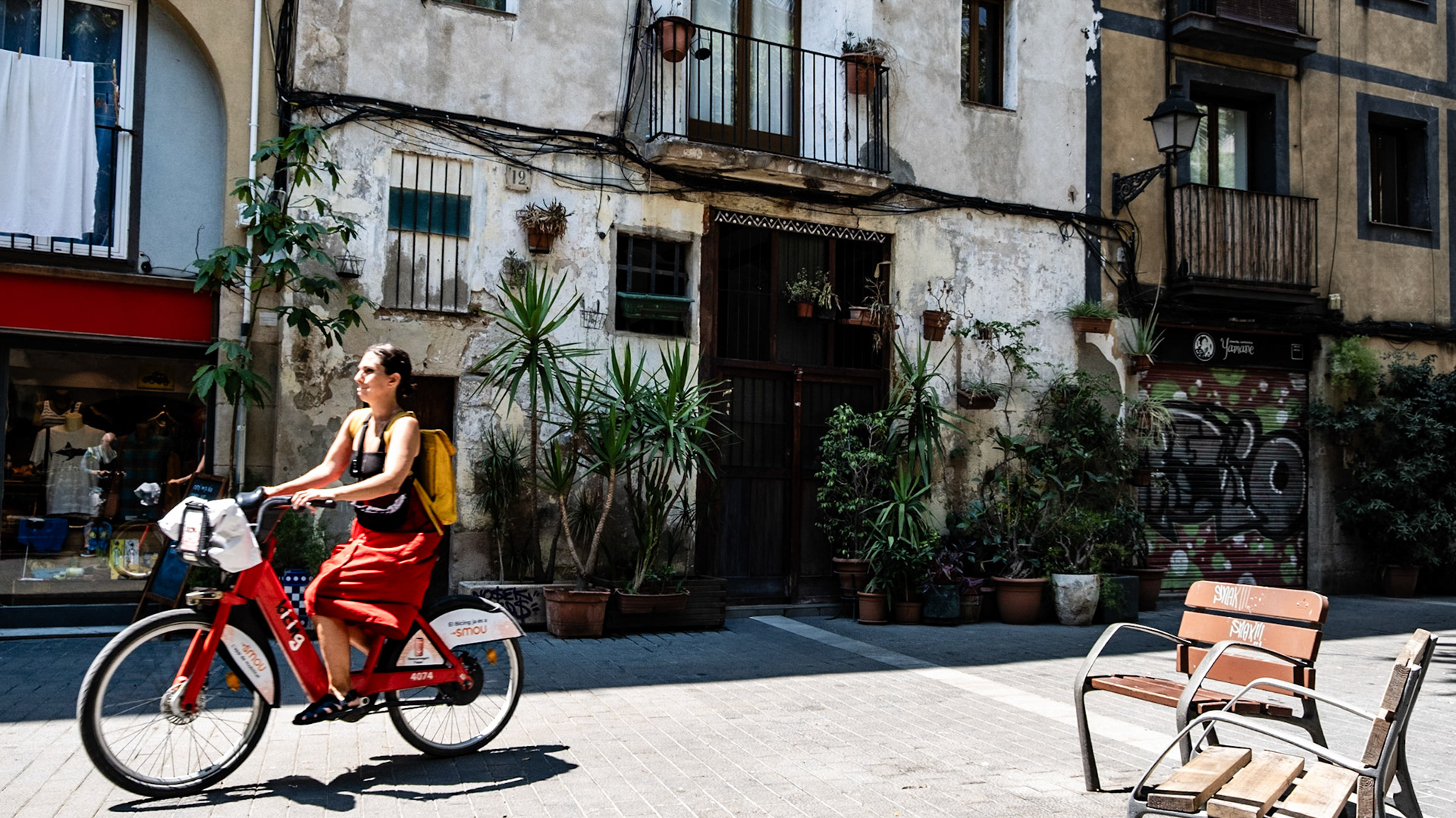 A woman rides a city bike on Carrer del l'Allada-Vermell in El Born district of Barcelona
