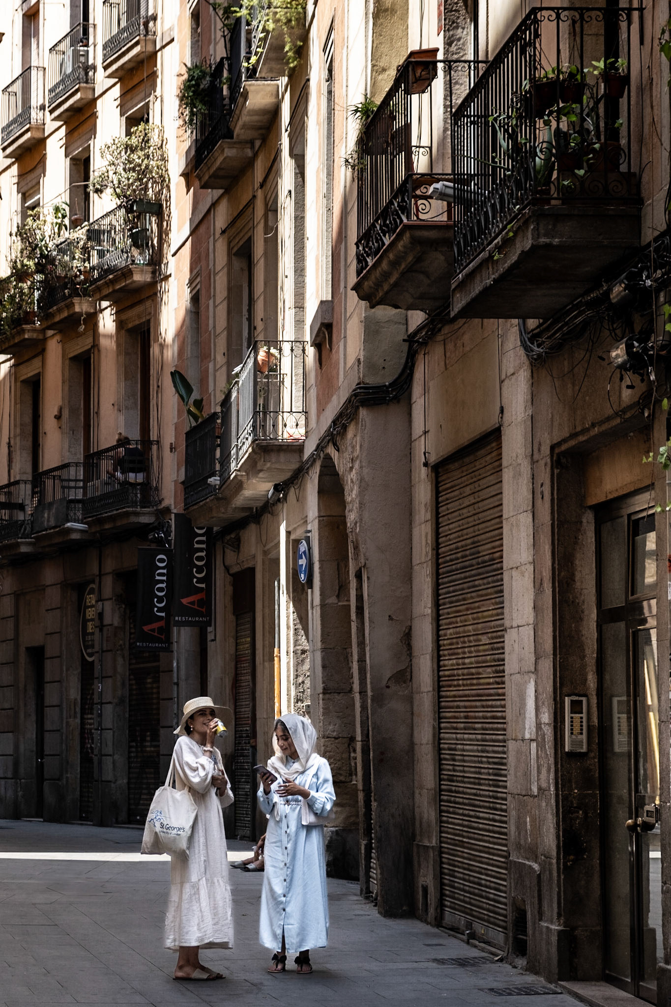 Two women in white stand on Via Laietana that separates Gothic Quarters from El Born districts in Barcelona