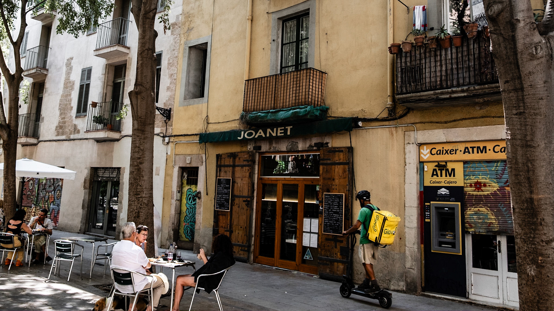 Locals and tourists alike enjoy their mid-day coffee on Plaça de Sant Aqusti Vell in Barcelona, surrouded by beautiful historic buildings