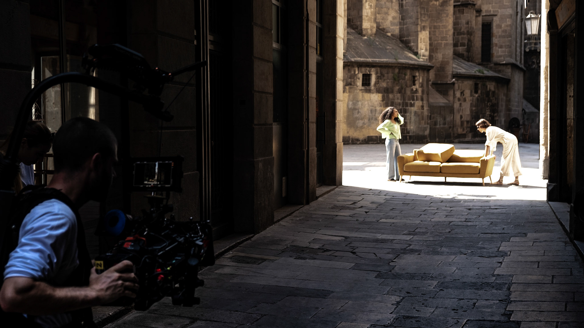 A film crew shoots an episode with a yellow sofa on the streets of historic Gothic Quarter in Barcelona