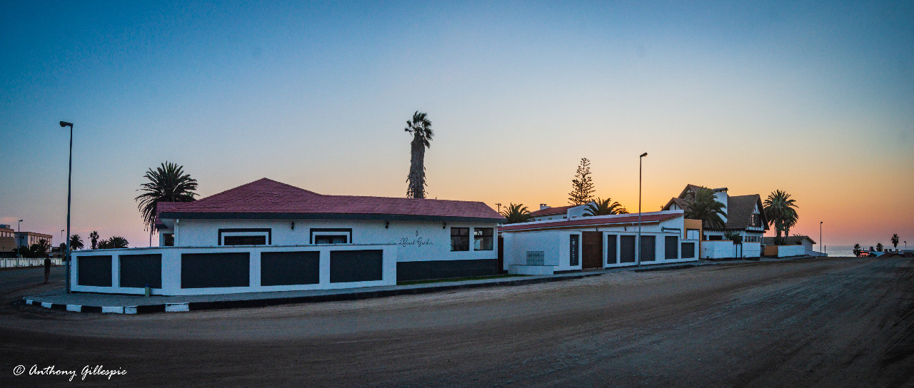 An outside corner view of Beach Garden Accomodation with a sea view.
