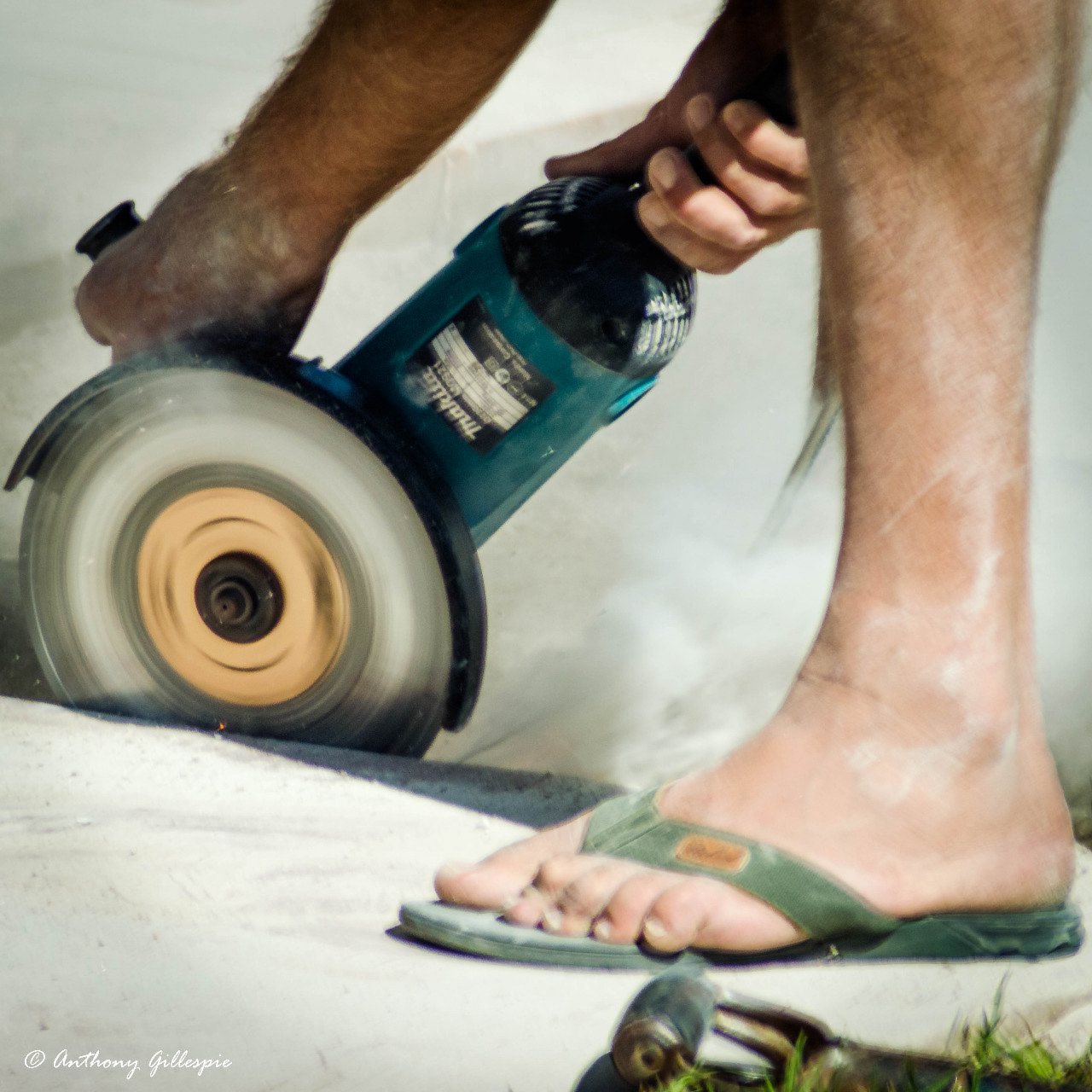 Grinding cement before laying paving in the courtyard in front of the bar.