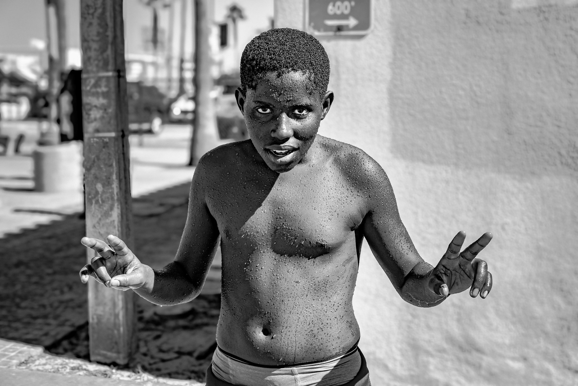This young boy just out of the shower on the boardwalk asked me to take his photo then struck this pose while his friends teased him