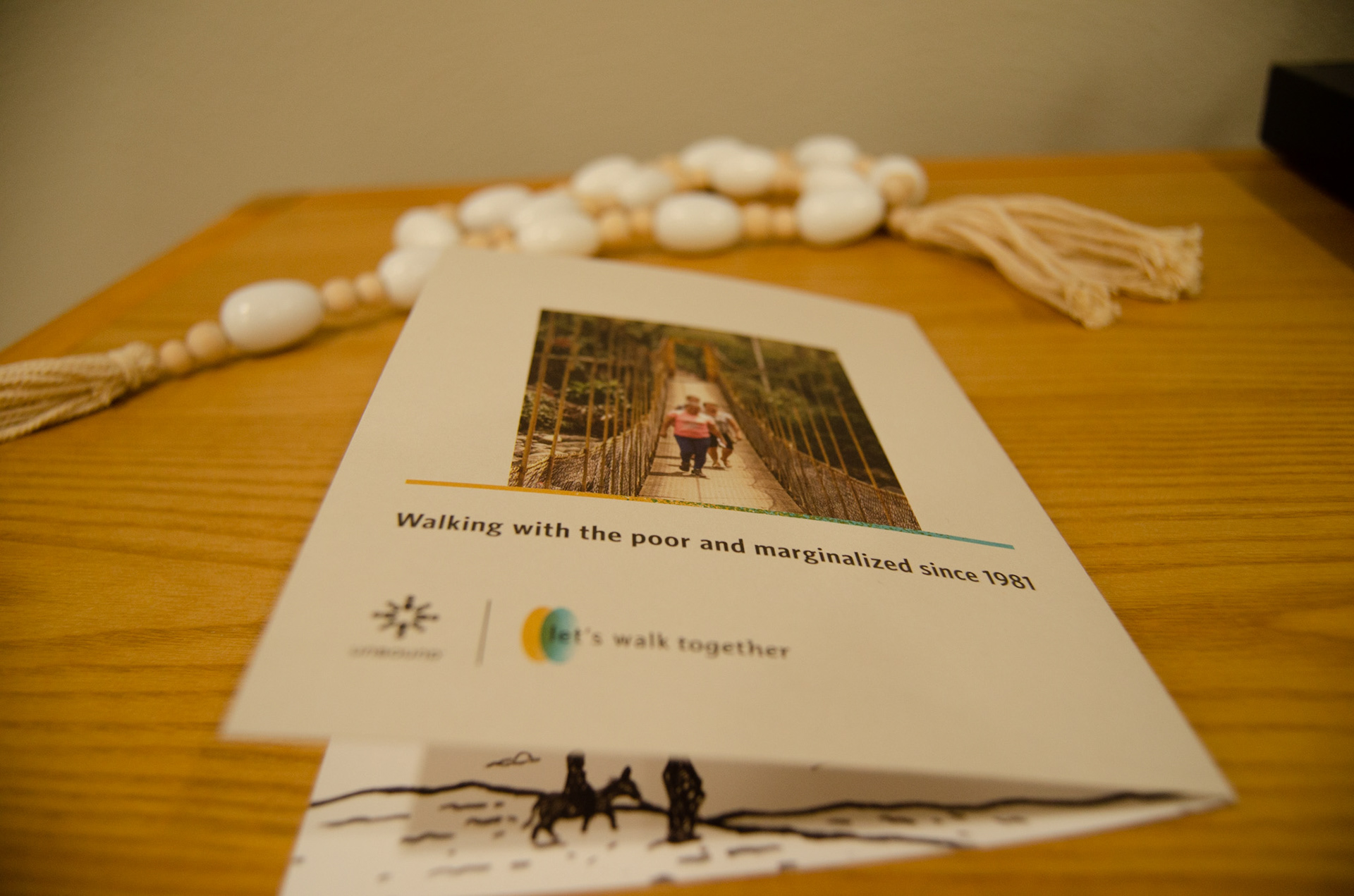The back of the card with a photo of Unbound mother walking across a bridge created by an Unbound Agents of Change grant.