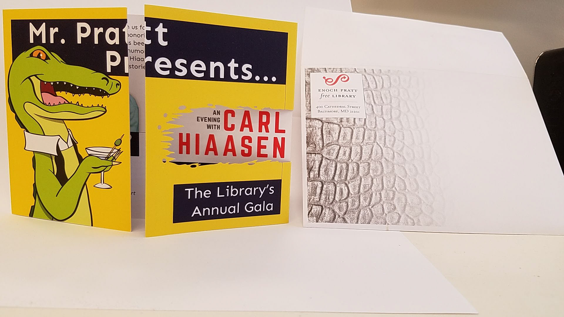 Invitation package for Enoch Pratt Free Library's annual gala including custom vector illustrations, 2019. Gatefold invitation with custom die cut in the shape of an alligator bite, envelope with alligator skin texture.