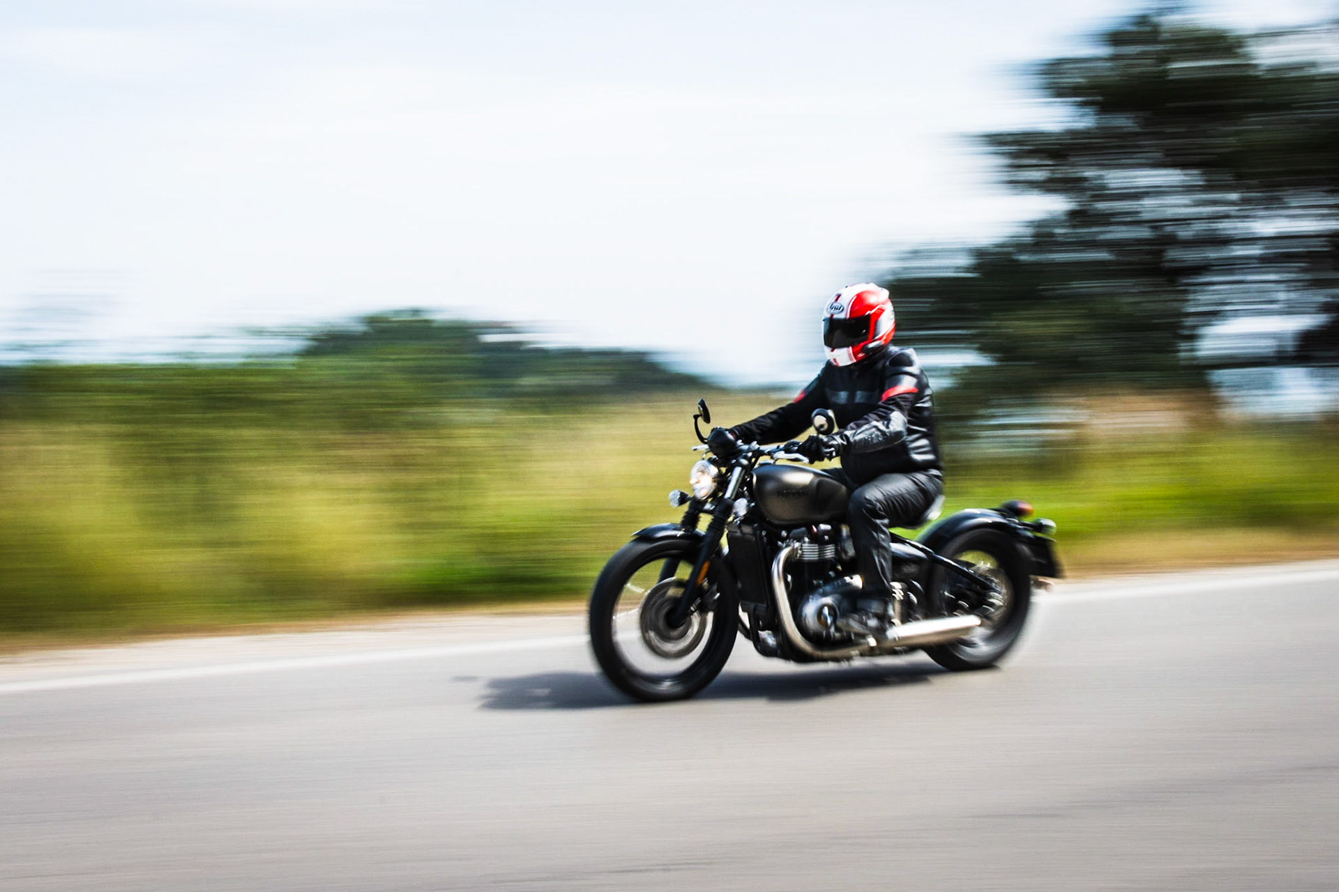 Motorcycle rider and his Triumph Bobber in motion