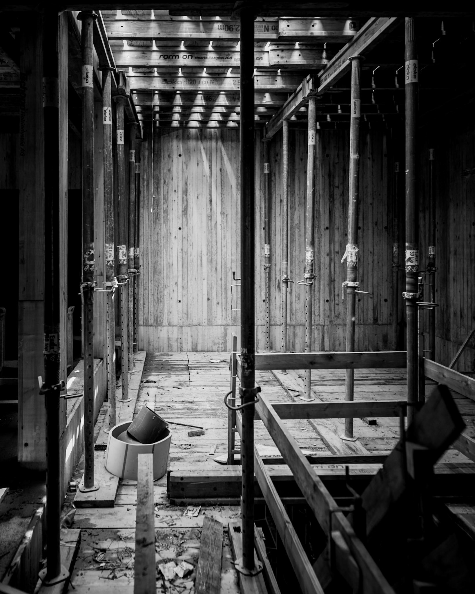 Baustelle in Schwarzweiss mit Holzgerüst und Betonwänden