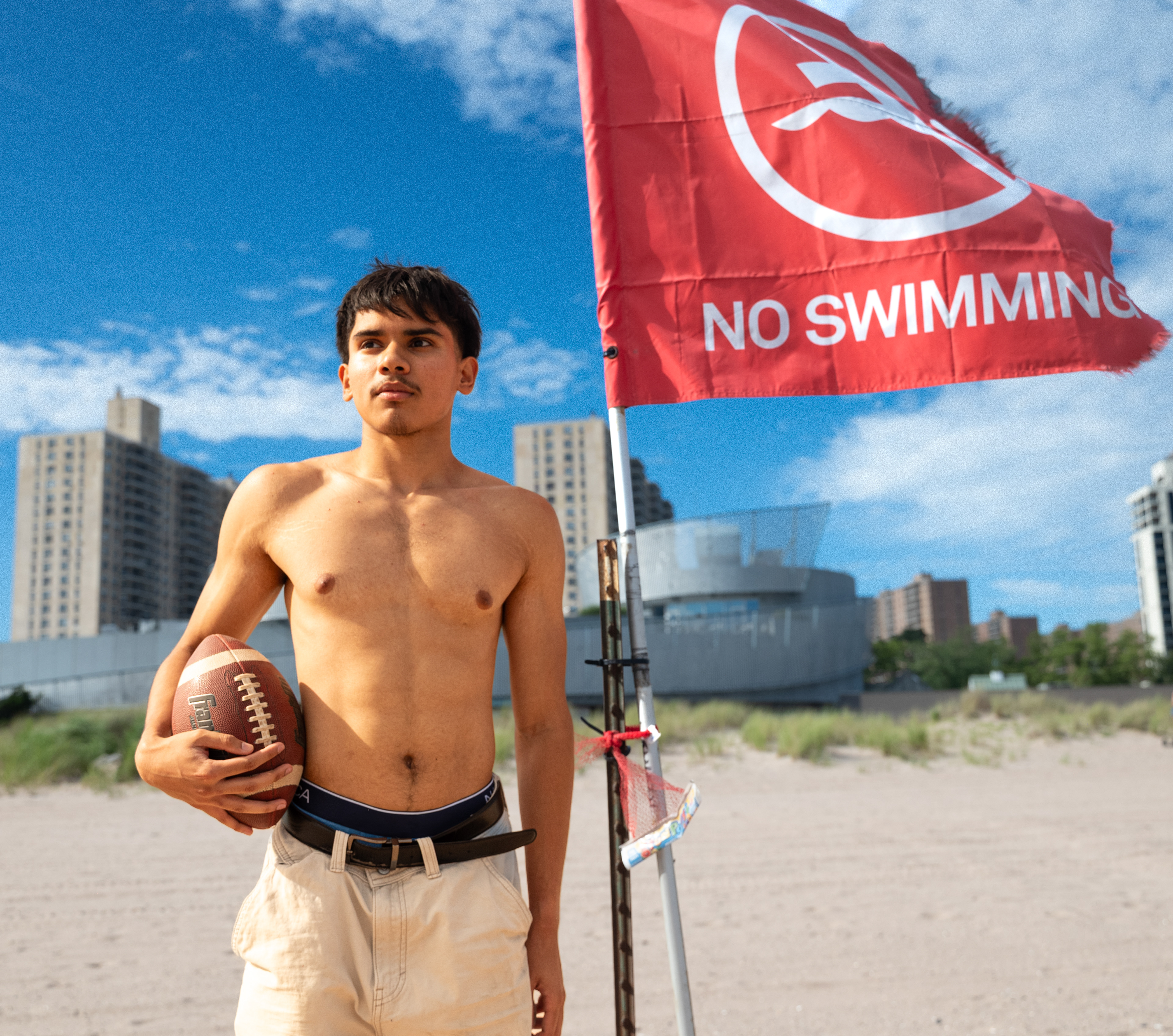 CONEY ISLAND, NEW YORK - JULY 19, 2025: Mohammed photographs an American football scene on the beach at Coney Island, Brooklyn, inspired by Top Gun: Maverick.