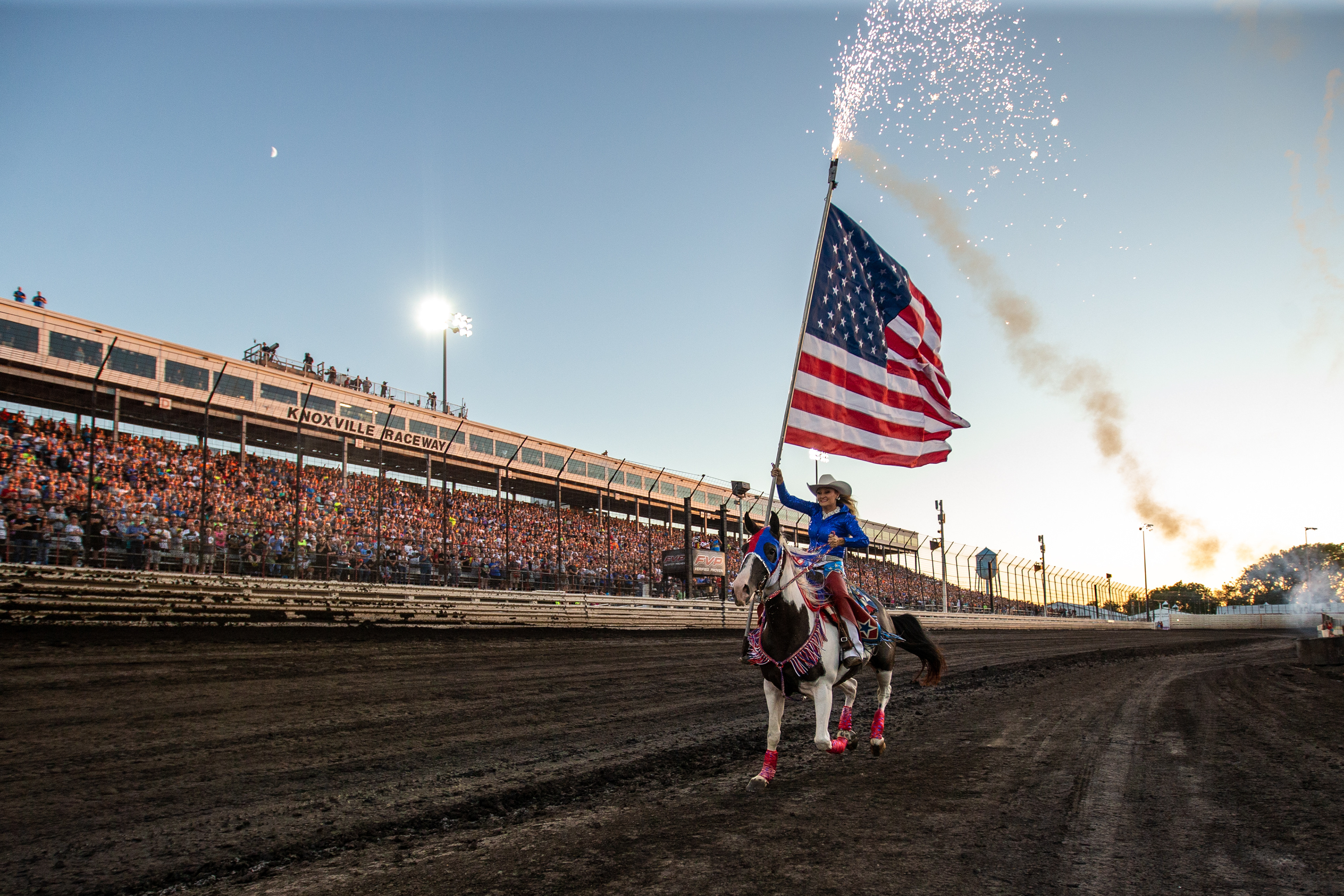 Jacee Wren, originally from Bryan, Texas but now living in Iowa, carries a sparkling American Flag on horseback during the National Anthem prior to the start of the 60th Annual NOS Energy Drink Knoxville Nationals presented by Caseys Championship Night at Knoxville Raceway in Knoxville, Iowa on Saturday, Aug. 14, 2021.