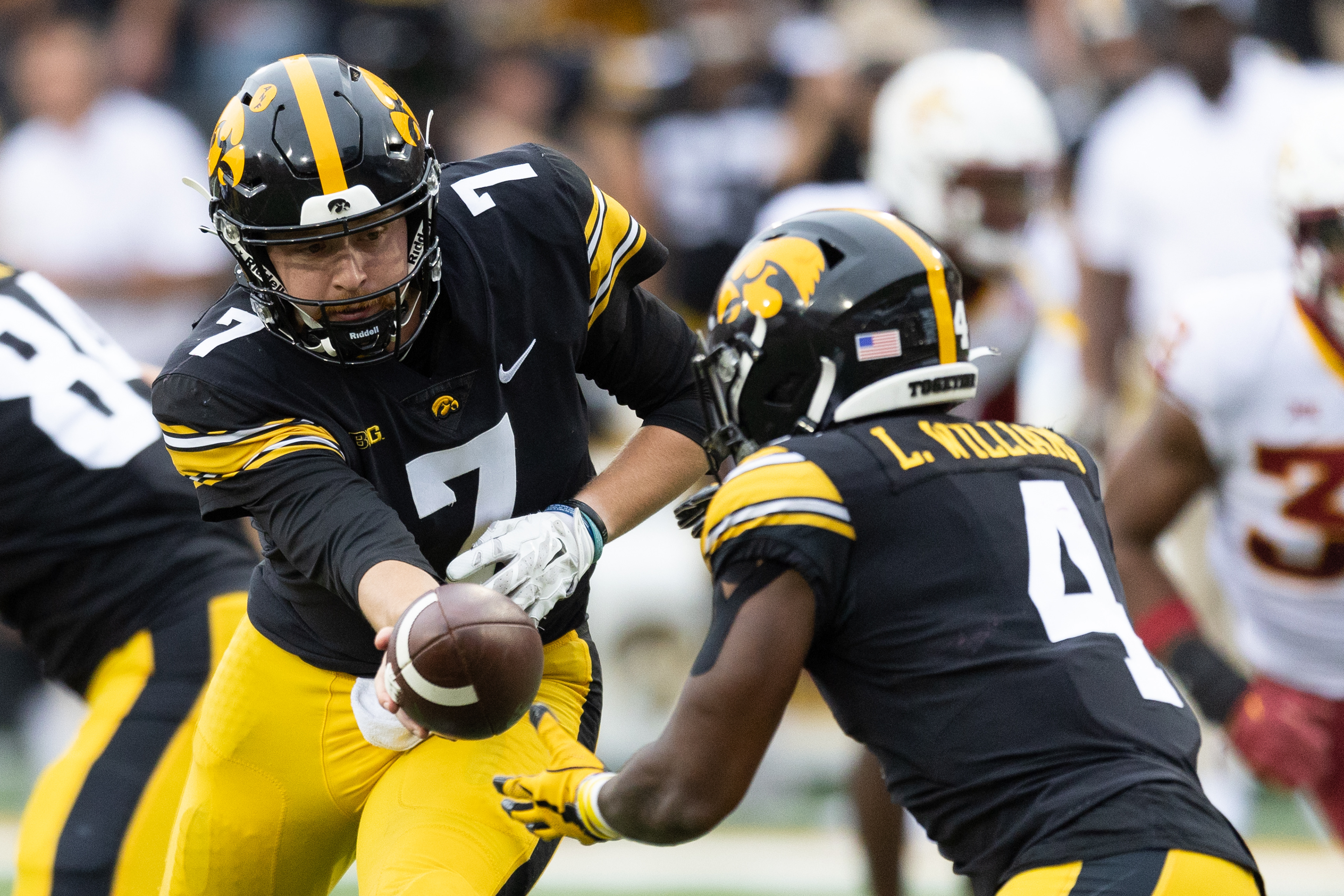 Iowa Hawkeyes quarterback Spencer Petras (7) hands the ball to Iowa Hawkeyes running back Leshon Williams (4) during a NCAA football game between the Iowa Hawkeyes and the Iowa State Cyclones at Kinnick Stadium in Iowa City, Iowa on Saturday, Sept. 10, 2022.
