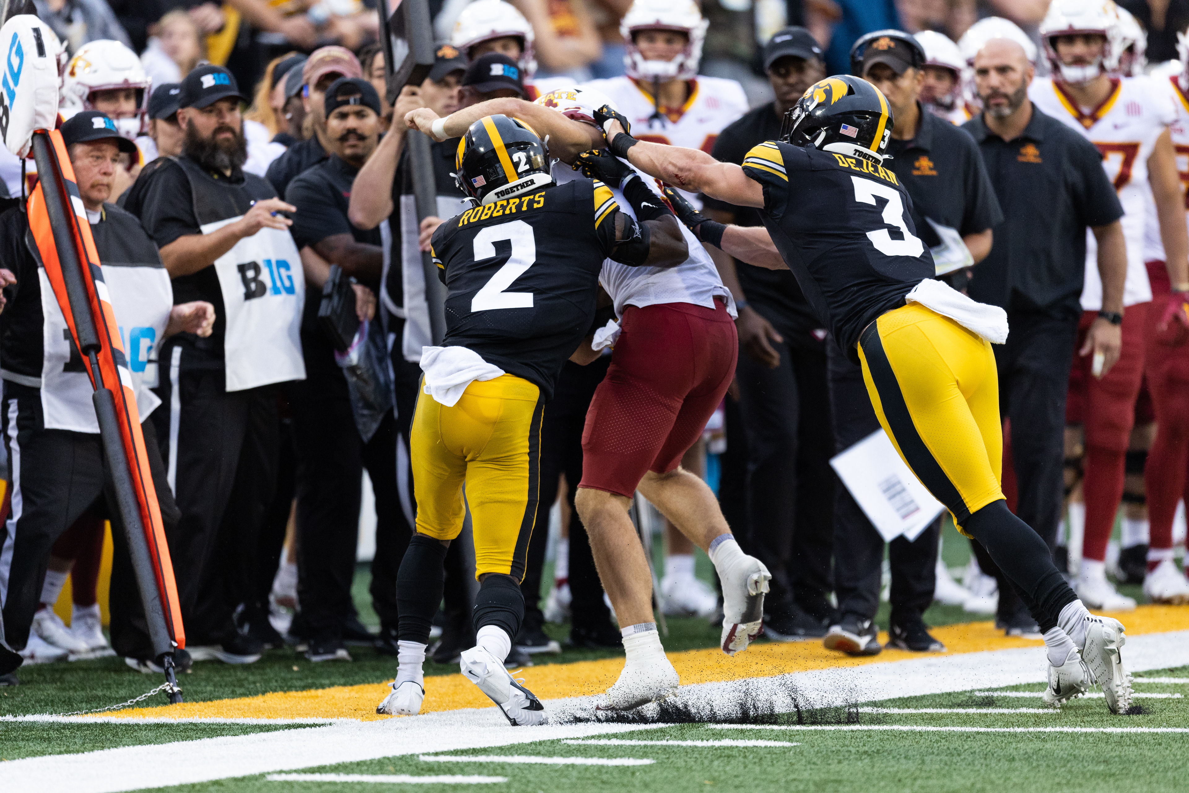 Iowa State Cyclones quarterback Hunter Dekkers (12) is pushed out of bounds by Iowa Hawkeyes defensive back Cooper DeJean (3) and Iowa Hawkeyes defensive back Terry Roberts (2) during a NCAA football game between the Iowa Hawkeyes and the Iowa State Cyclones at Kinnick Stadium in Iowa City, Iowa on Saturday, Sept. 10, 2022.
