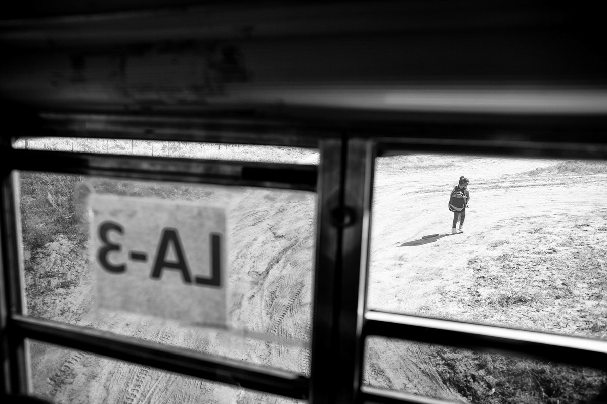 Child exits bus and walks up driveway to home.