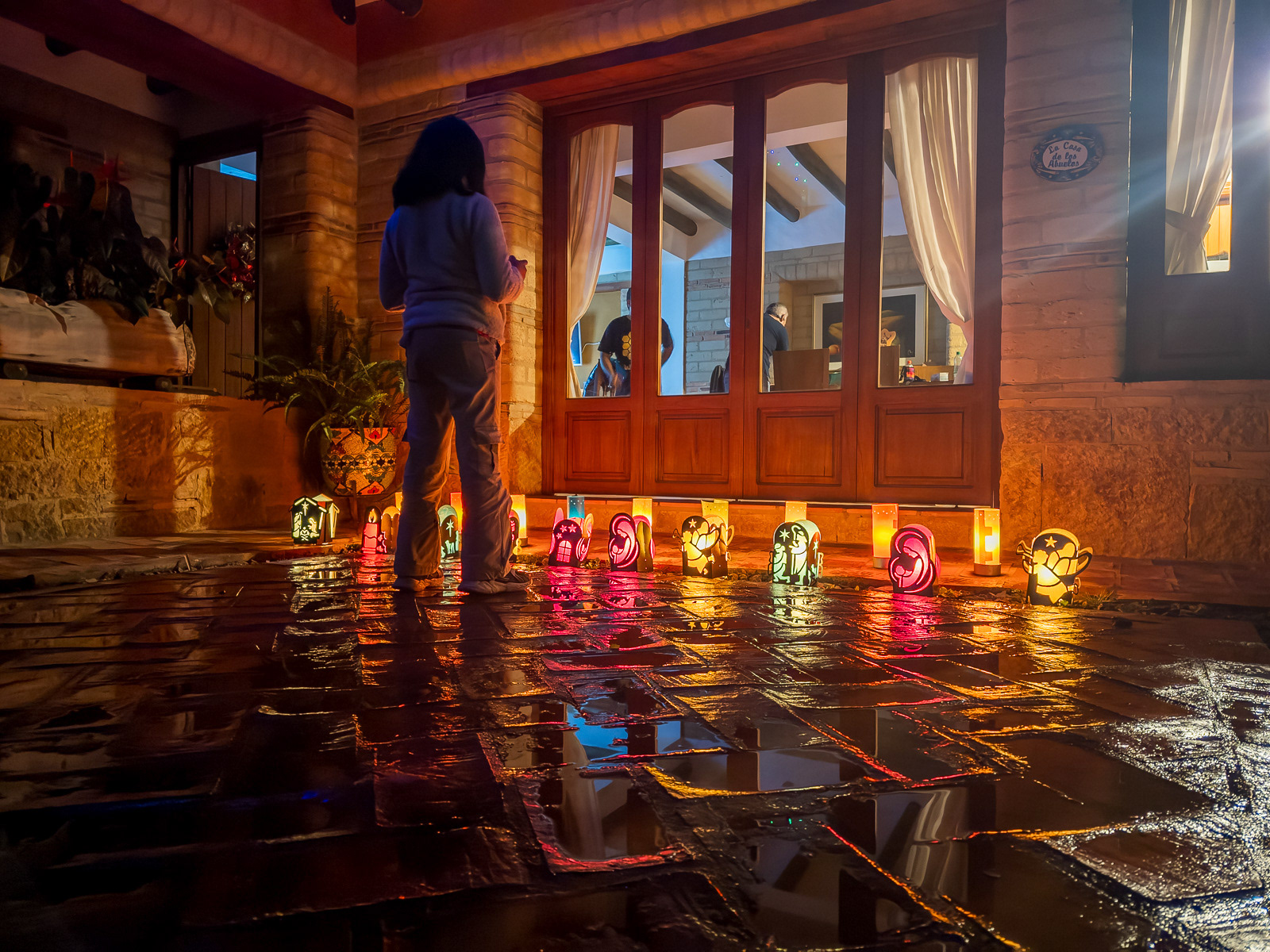 Favorita 7 de 2025: día de velitas. Esta foto entró a las favoritas después que había hecho la selección. Es algo que sabía que podía suceder. Remplazó a otra que ahora está entre las cuasifavoritas. Es favorita porque es la única de las 12 que tiene personas, por los reflejos y por la silueta y por los recuerdos de ese viaje al festival de luces de Villa de Leyva.