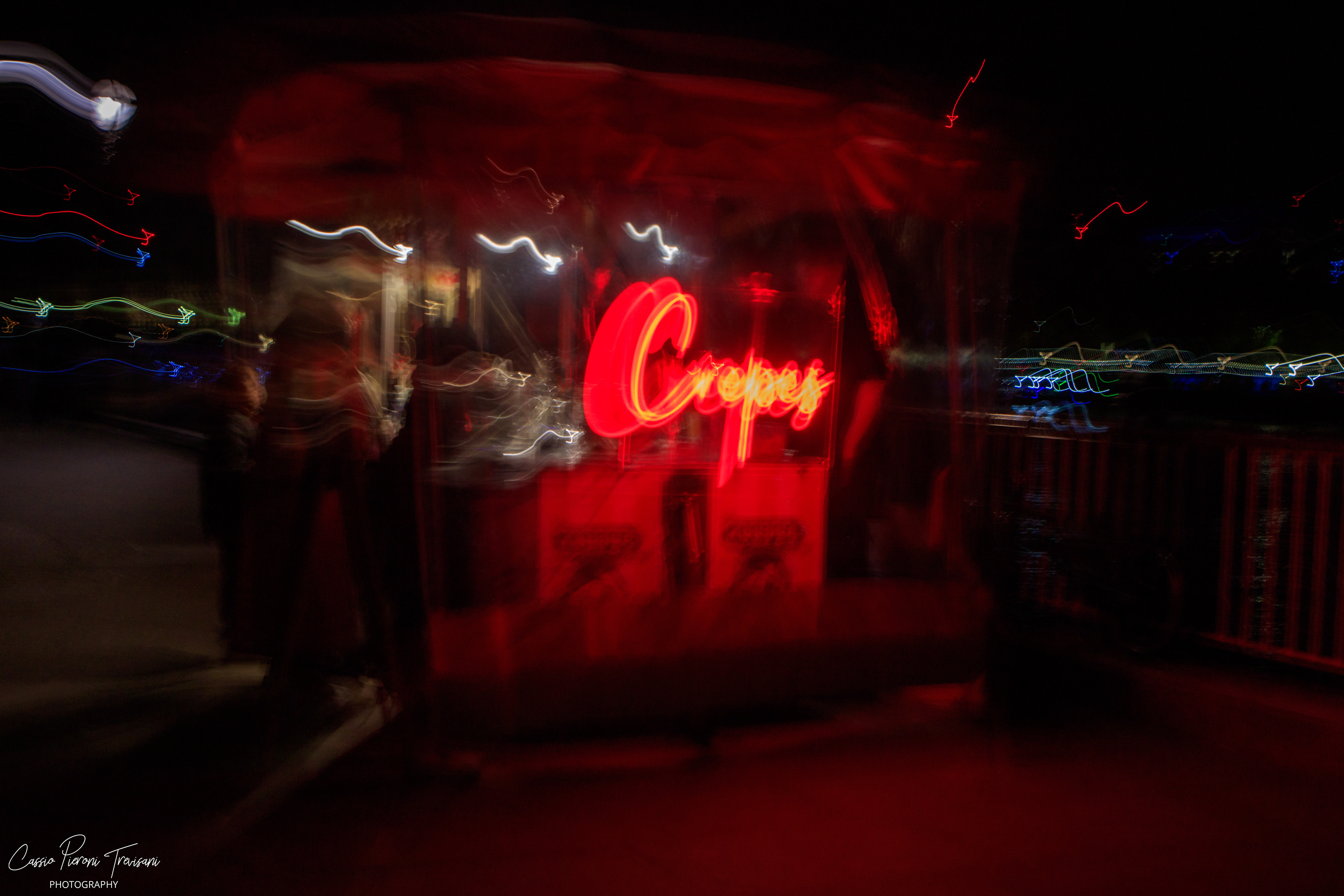 A flash of red in the darkness, where neon light and movement dissolve into a cinematic blur.