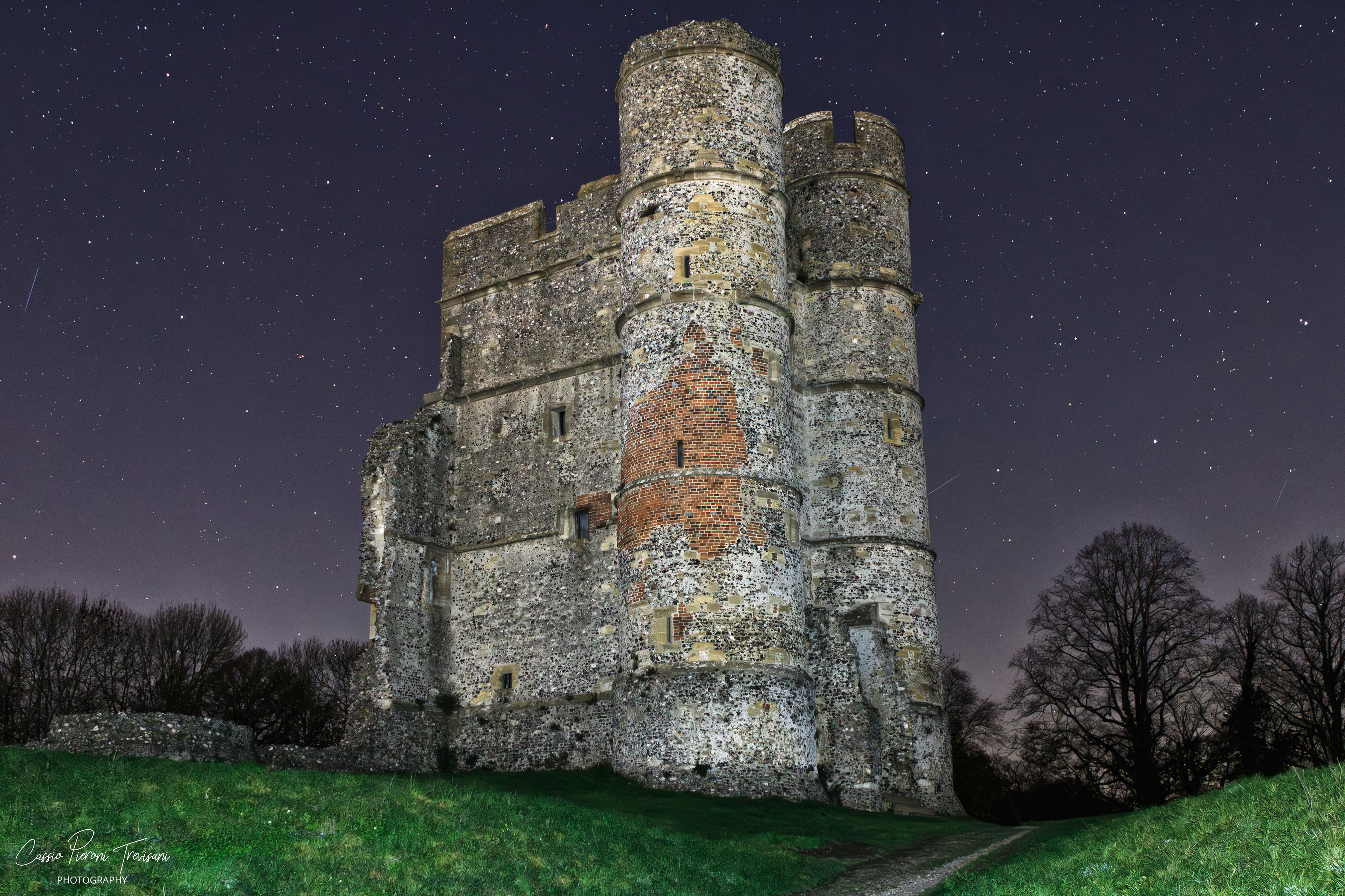 Night photograph of Donnington Castle illuminated against a clear starry sky in Berkshire.