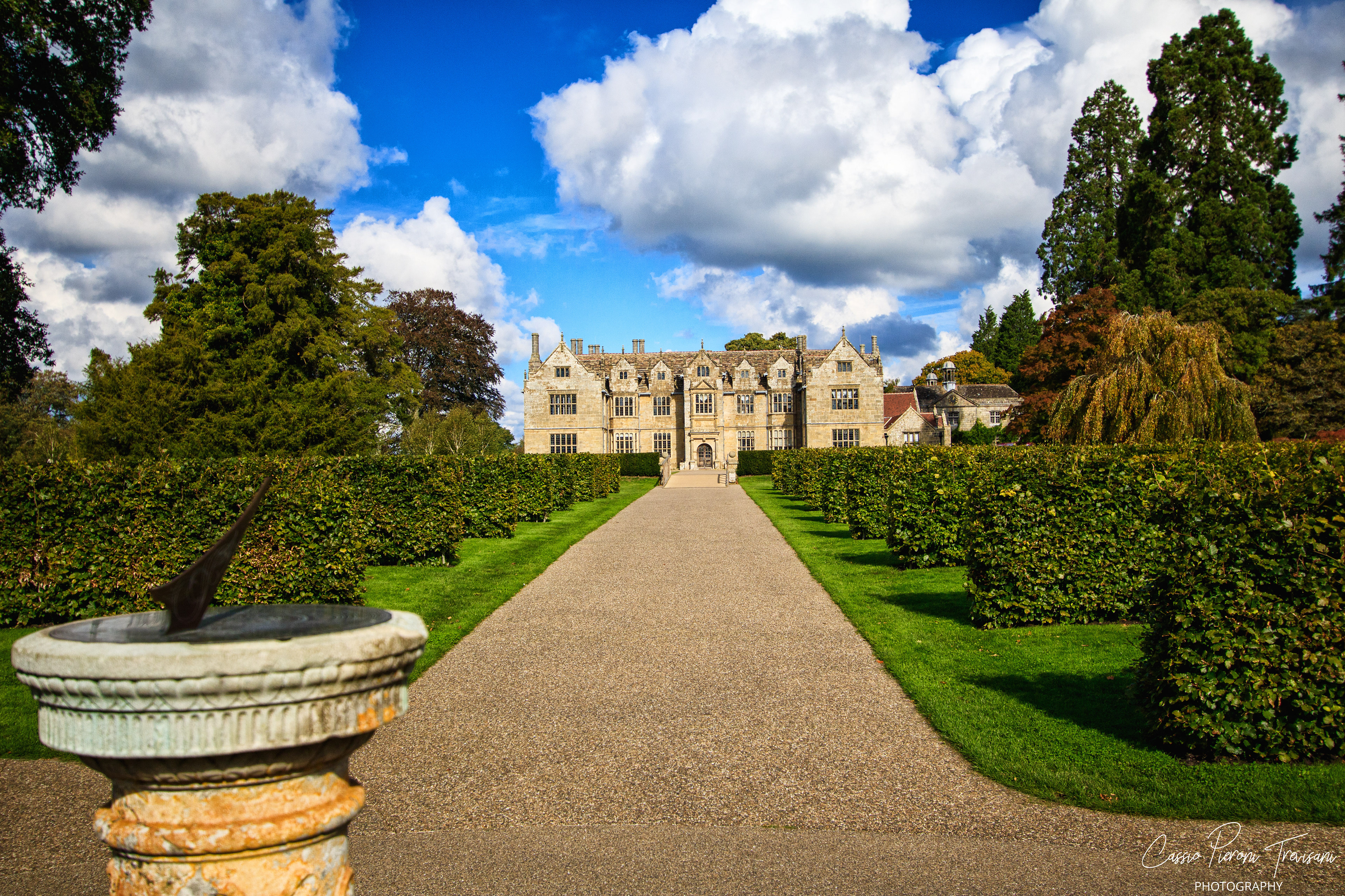 Wakehurst Place framed by formal gardens and dramatic skies.