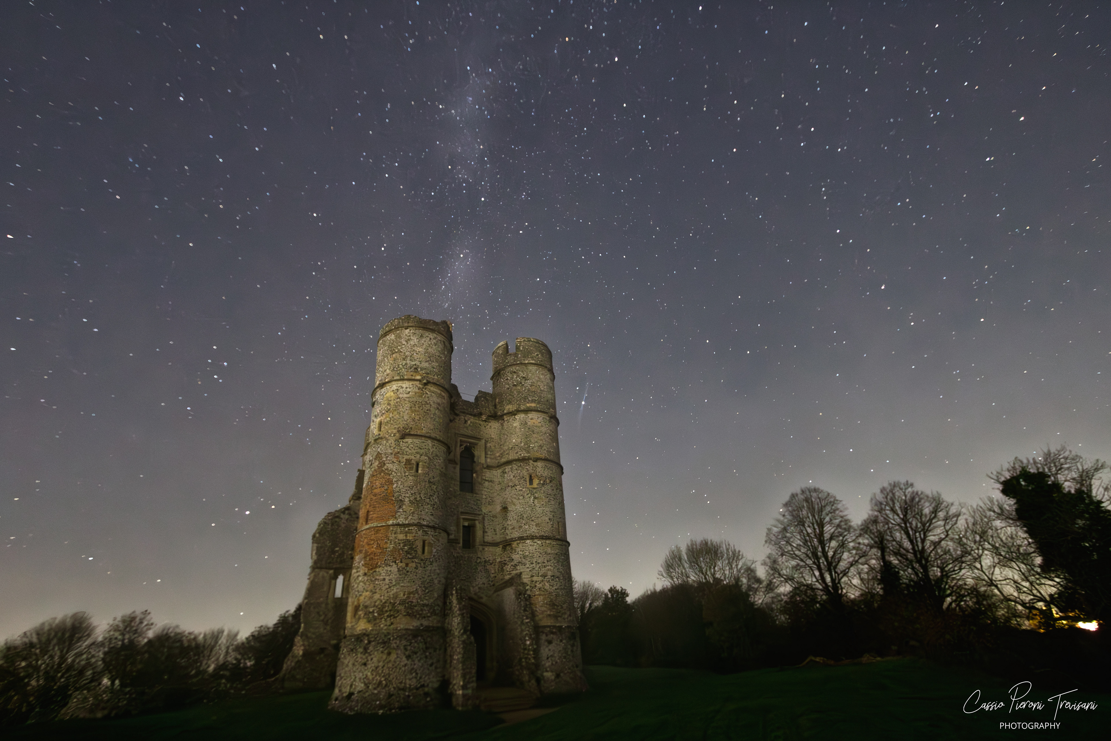 Donnington Castle at night beneath a clear star field and subtle Milky Way streak.