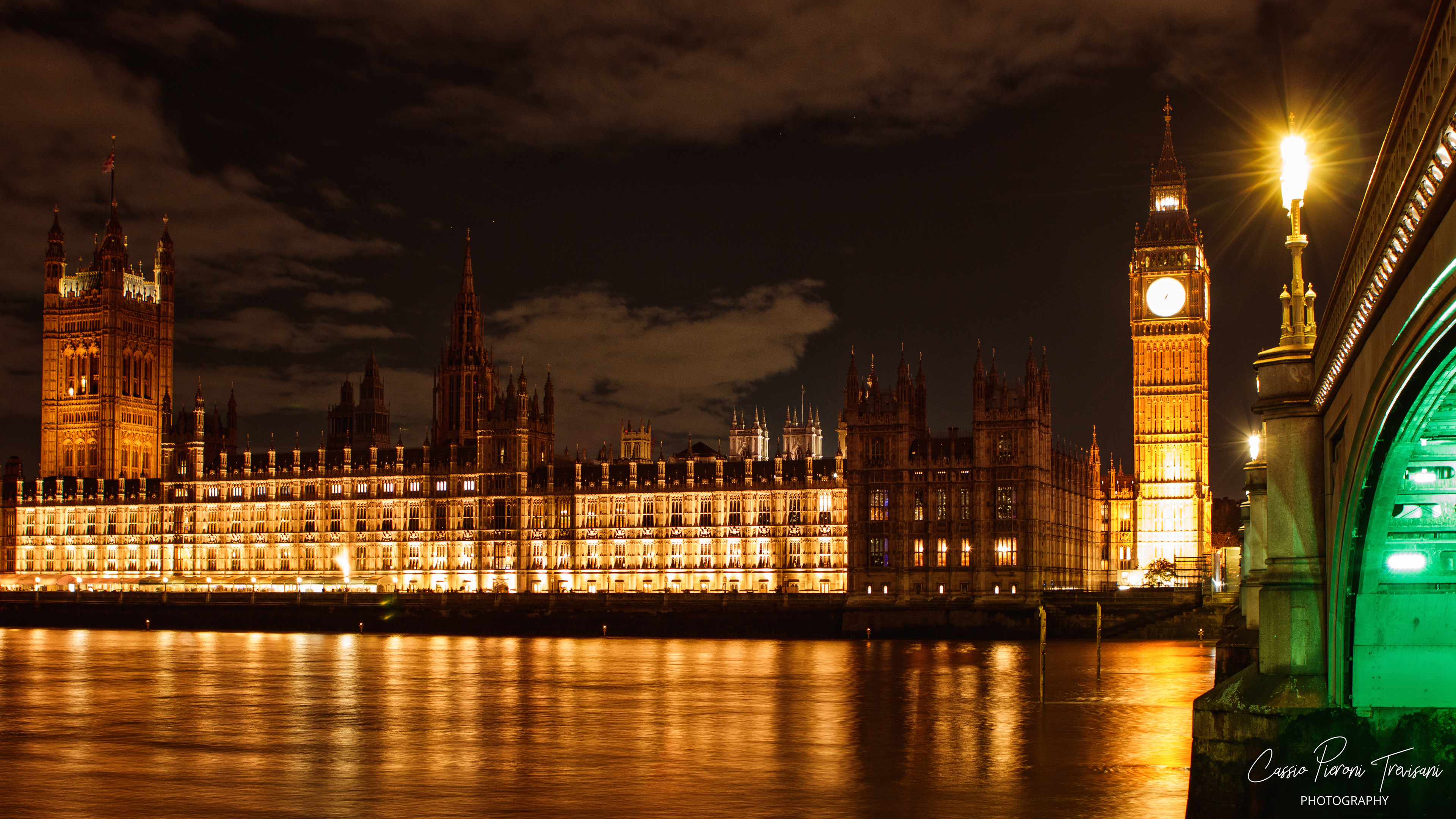 Framed by Westminster Bridge, Big Ben rises in warm light as the Palace of Westminster glows across the Thames, reflections rippling through the night.