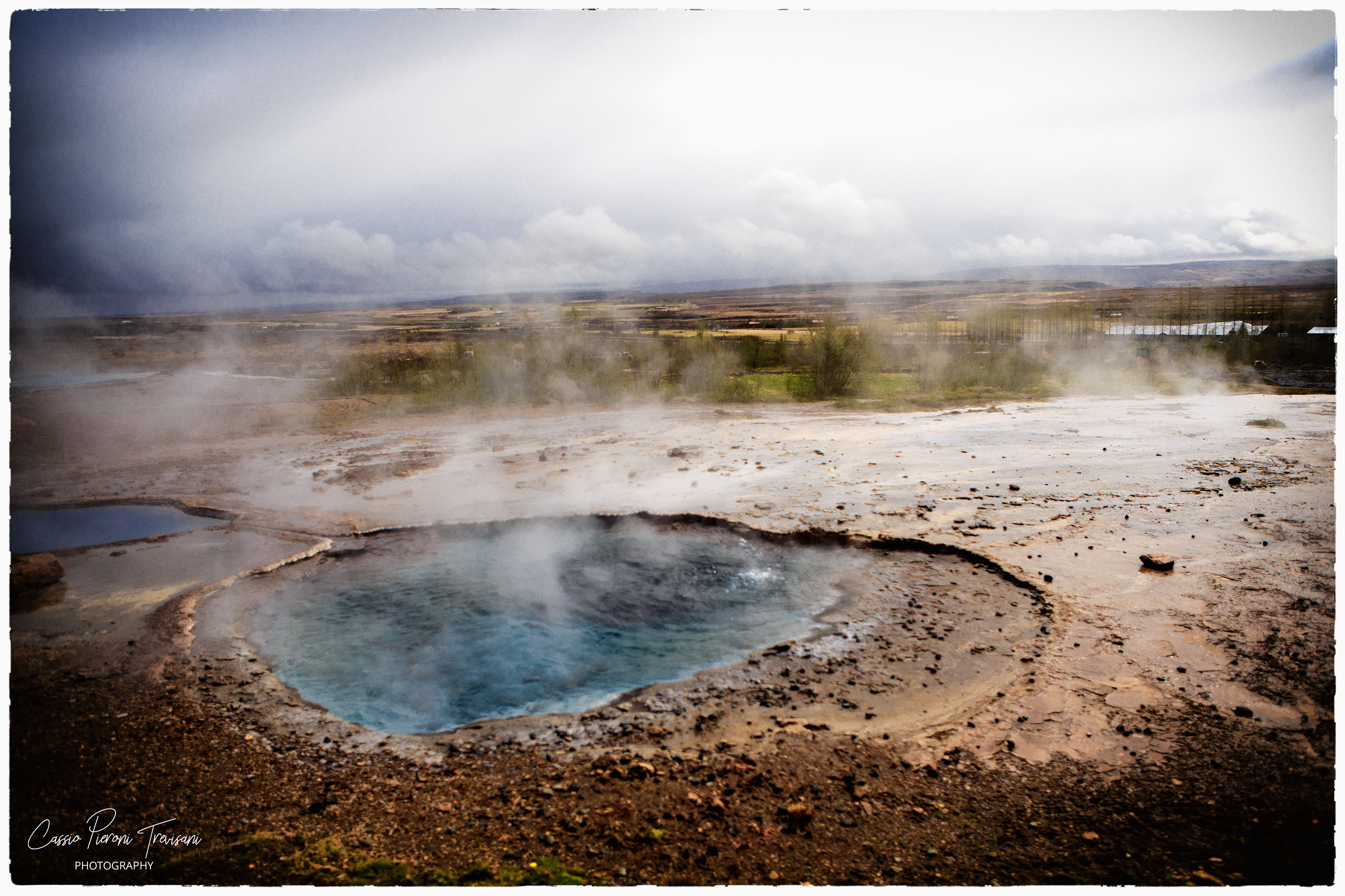 A steaming blue geothermal pool sits beneath a stormy sky, revealing the heat and colour hidden beneath Iceland’s surface.