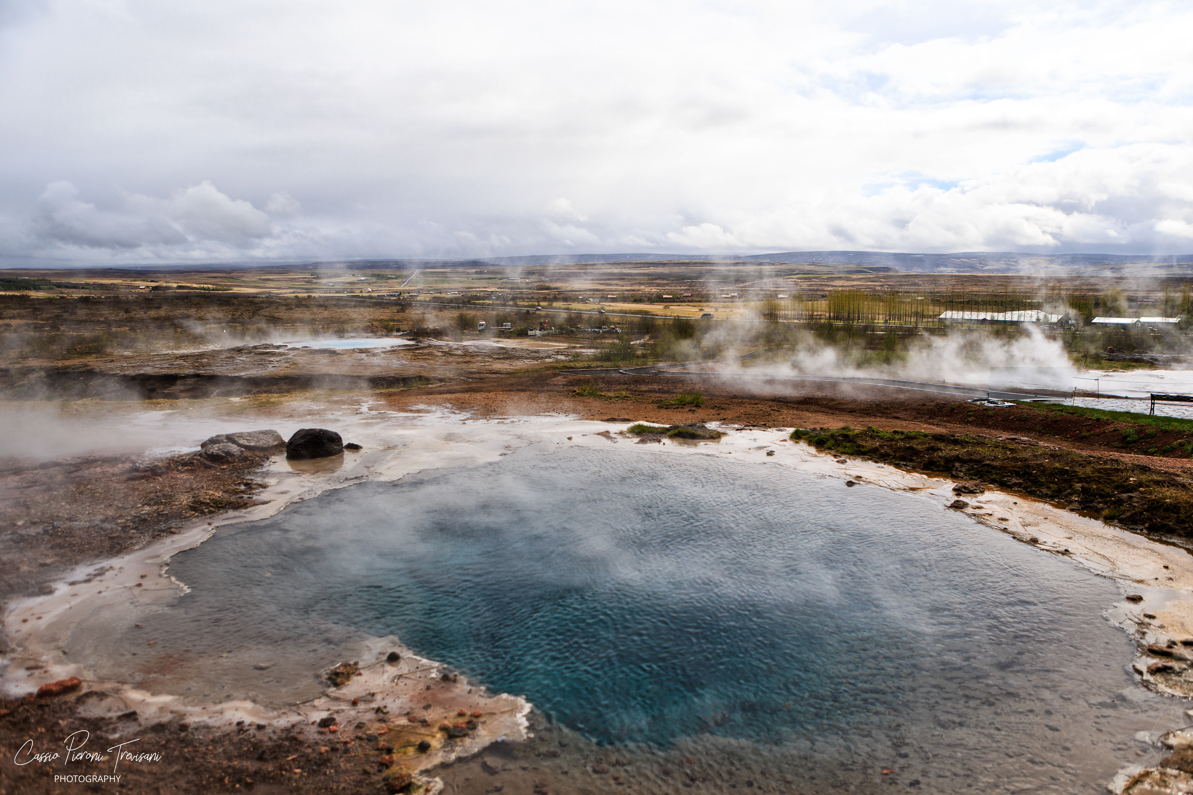 The geothermal valley of Haukadalur breathes steam across the landscape, turning the earth into a living volcanic scene.
