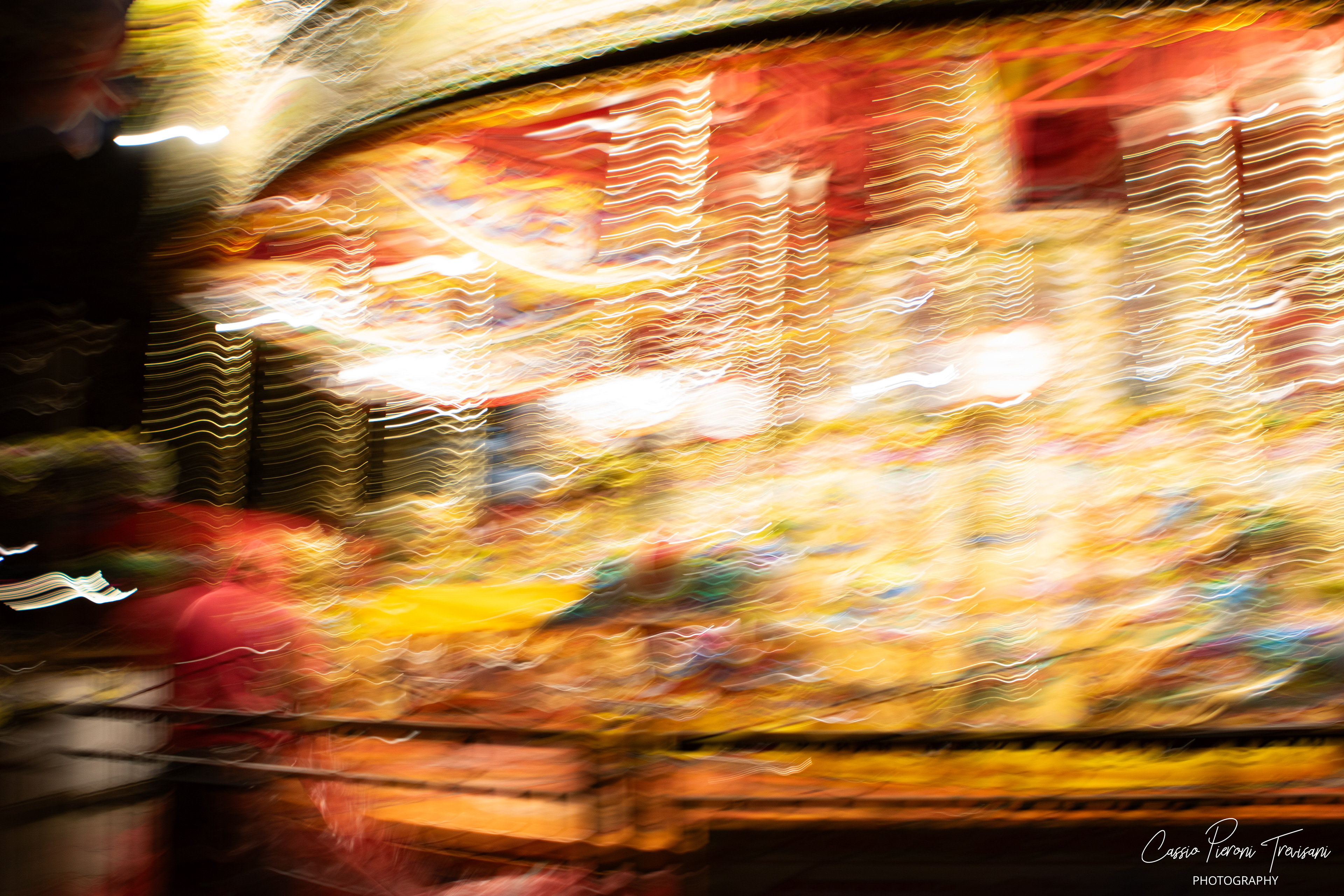 Round and round it turns, dissolving into streaks of gold — a fleeting fairground moment suspended in time.