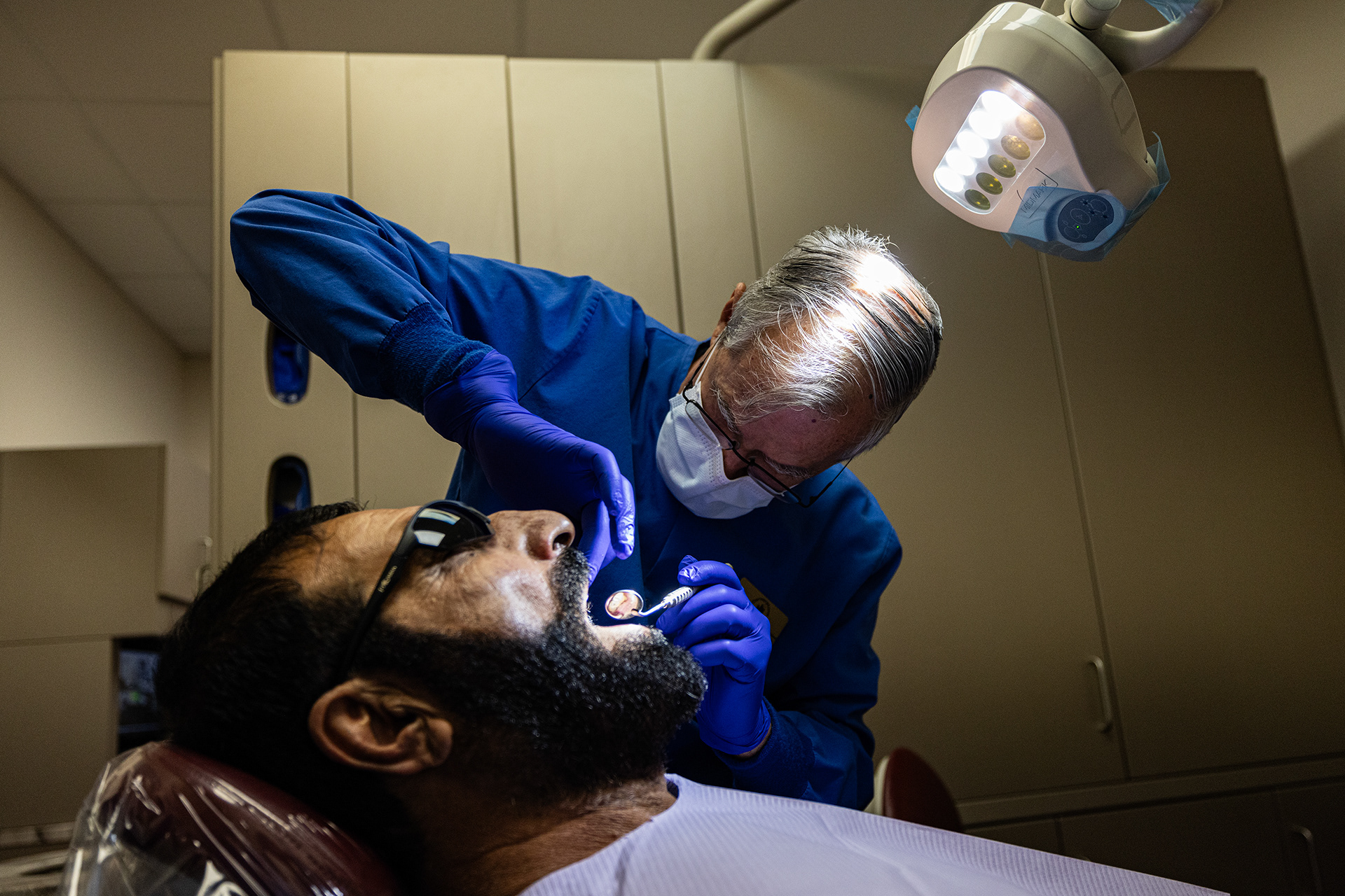 Dentist Stan Fitzer works on Mohamed Amini, an Afghan refugee who fled Afghanistan following the Taliban takeover, at Cornerstone Assistance Network in Fort Worth.
