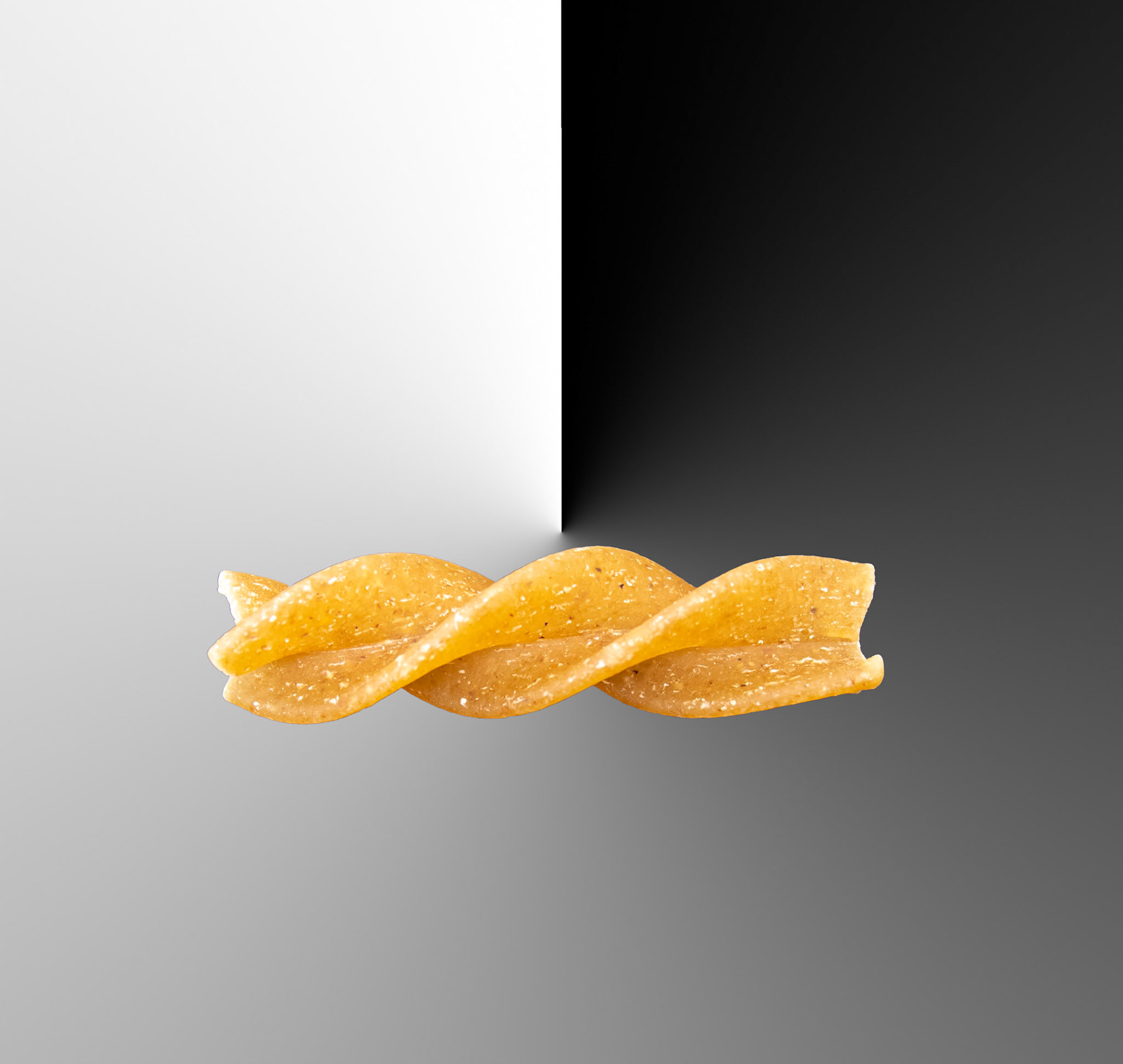 A single piece of fusilli pasta makes a composite picture edited in Photoshop.