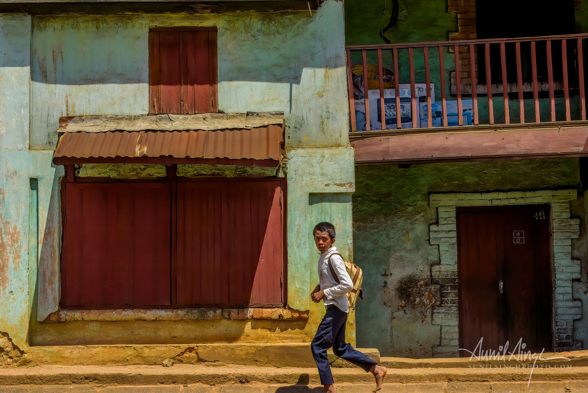 A boy running back home after school, Ambatolampy, Madagascar