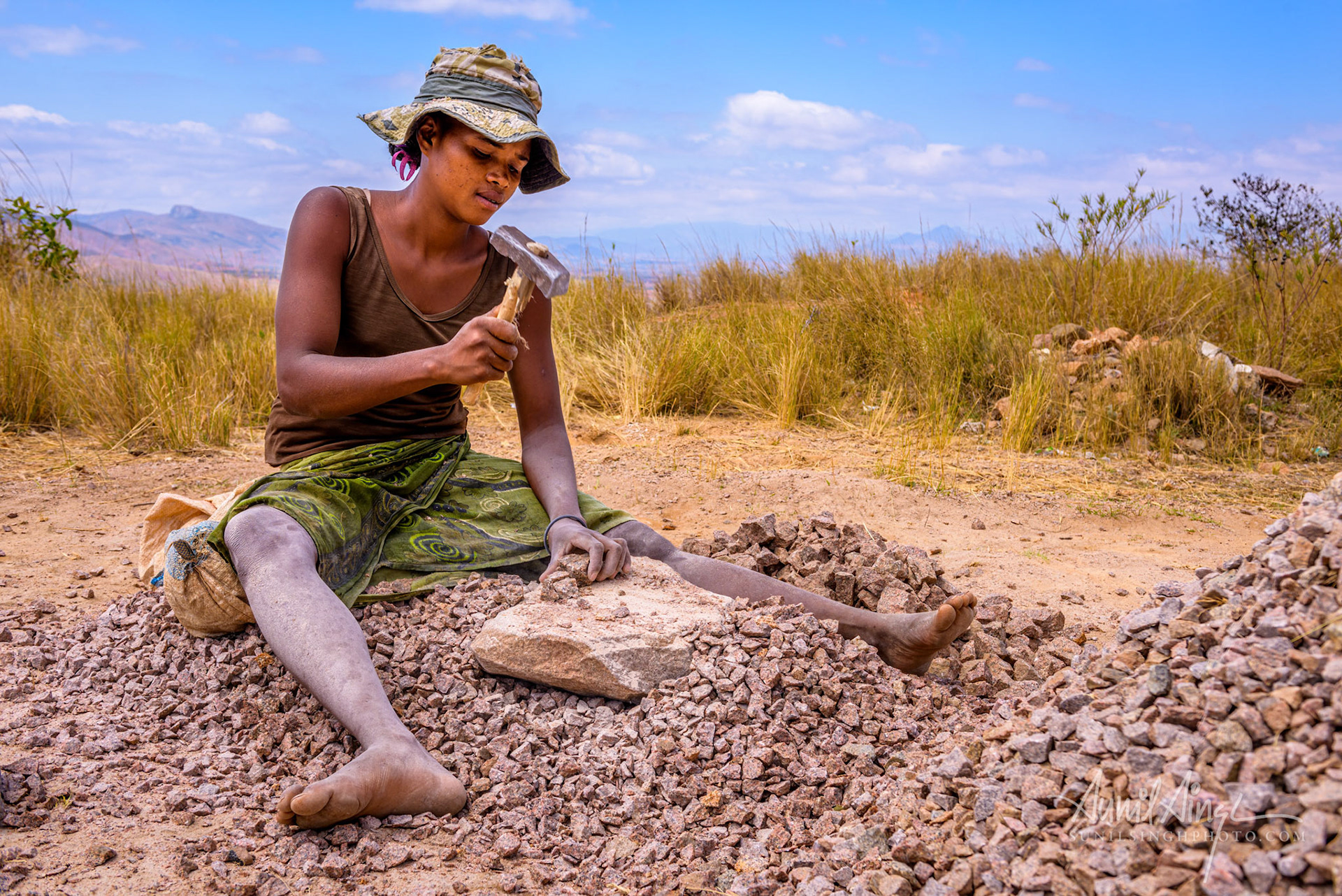 Woman crushing stones for road construction, Ranomafana to Isalo, Madagascar
