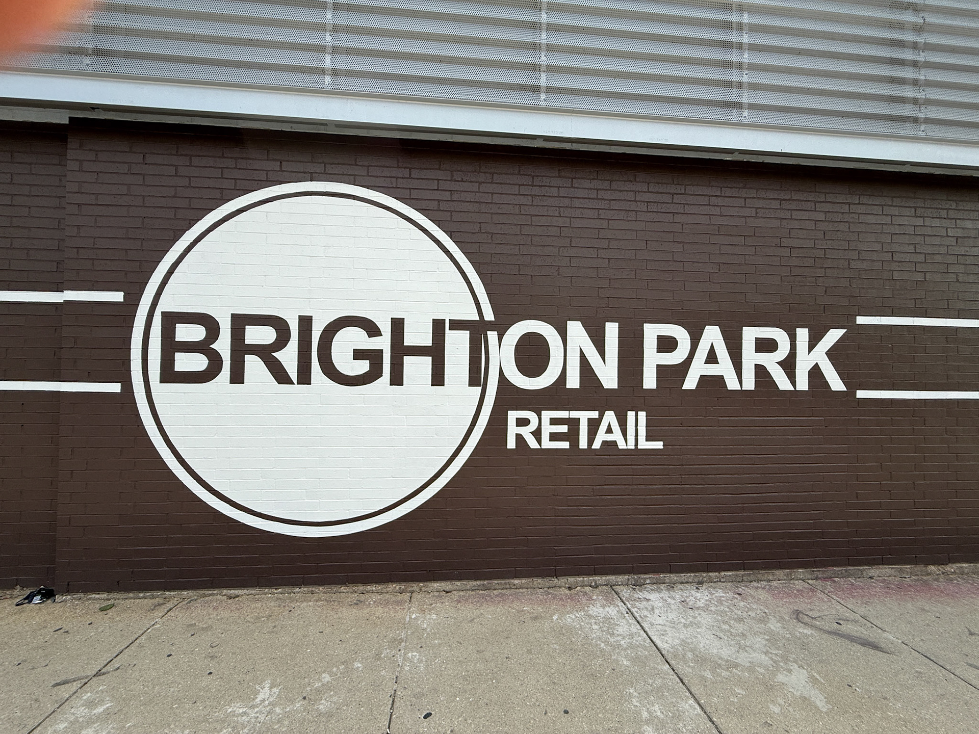 'BRIGHTON PARK RETAIL' logo circle on brown brick exterior in downtown Chicago