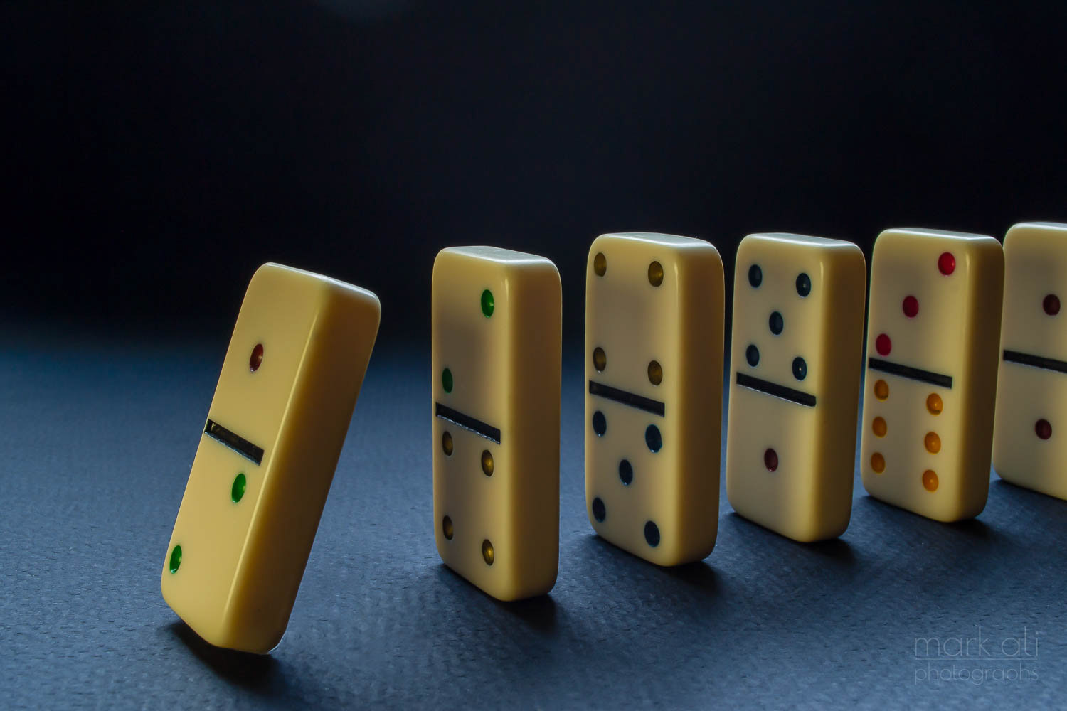 An image of a line of dominoes standing on end, with the first one about to fall.