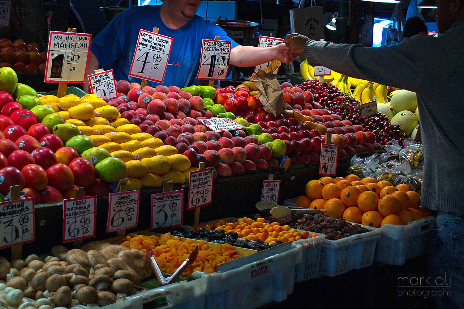 A fruit vendor makes a sale at Pike Place Market in Seattle.