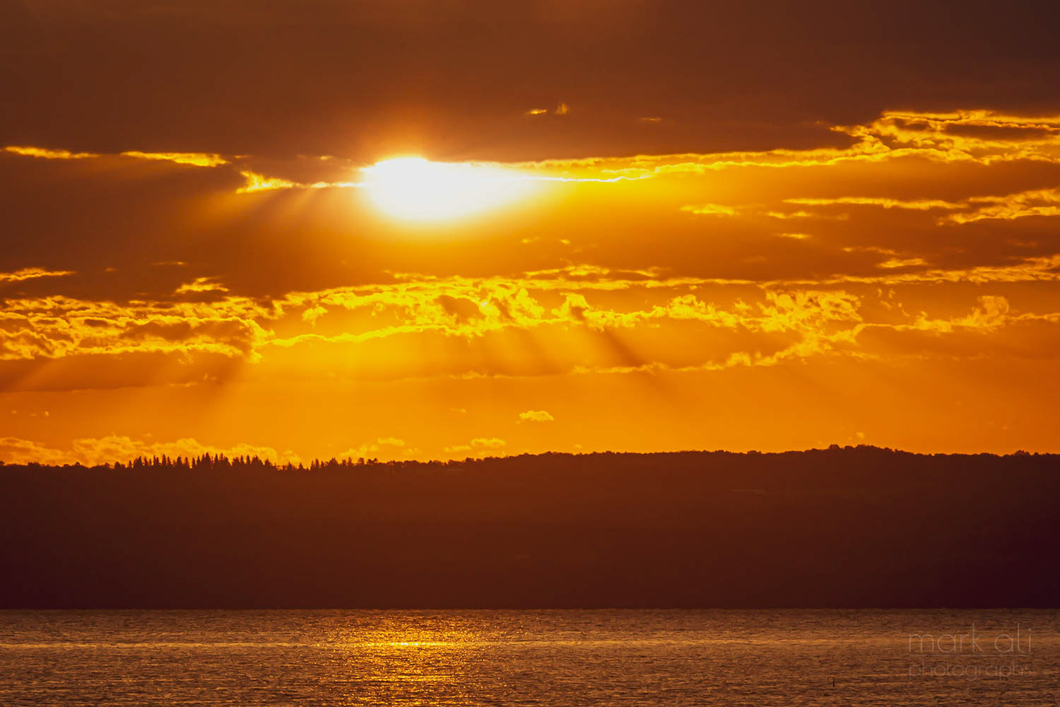 The sun rises over a lake.