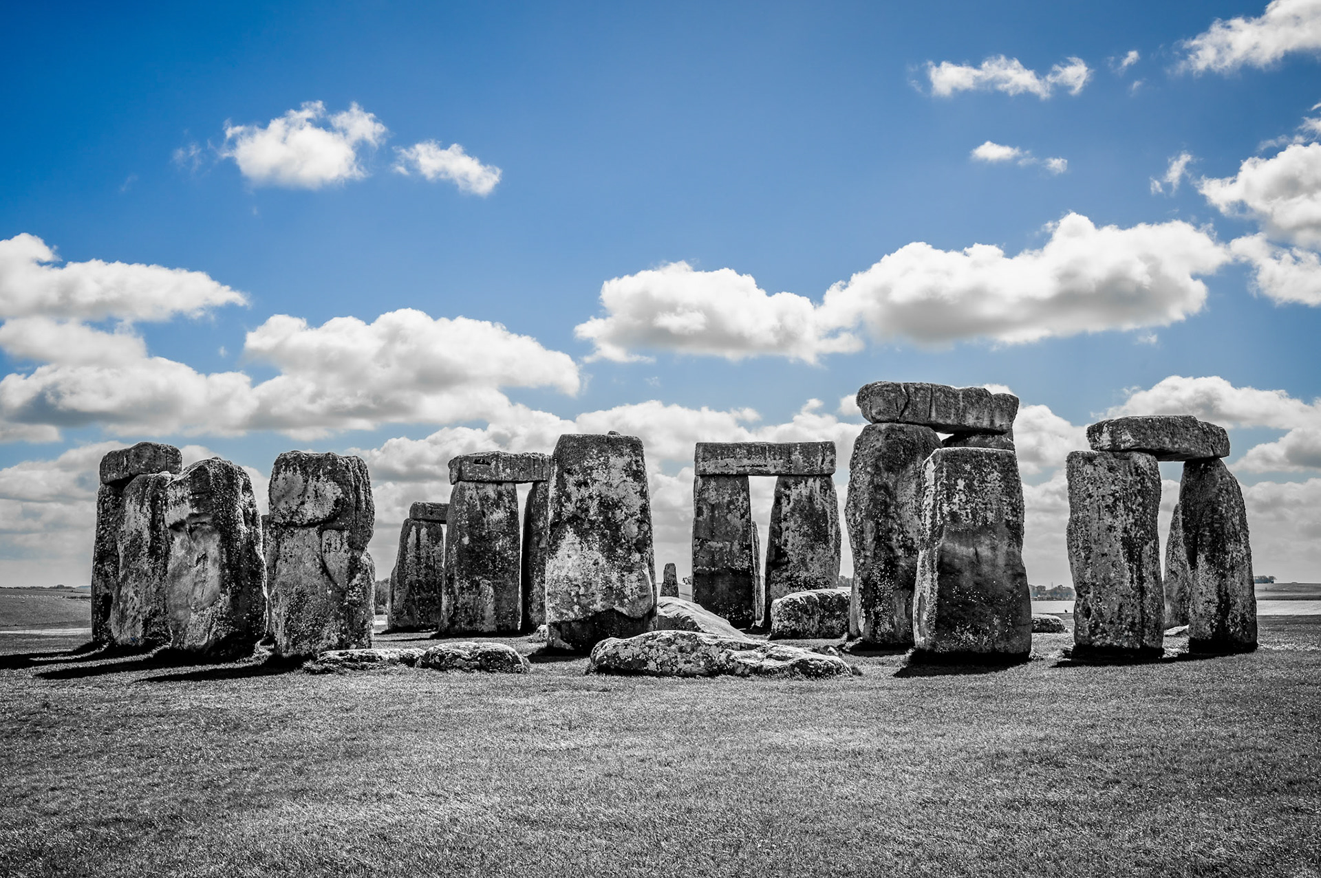 An artsy rendition of Stonehenge, under a bright blue sky.