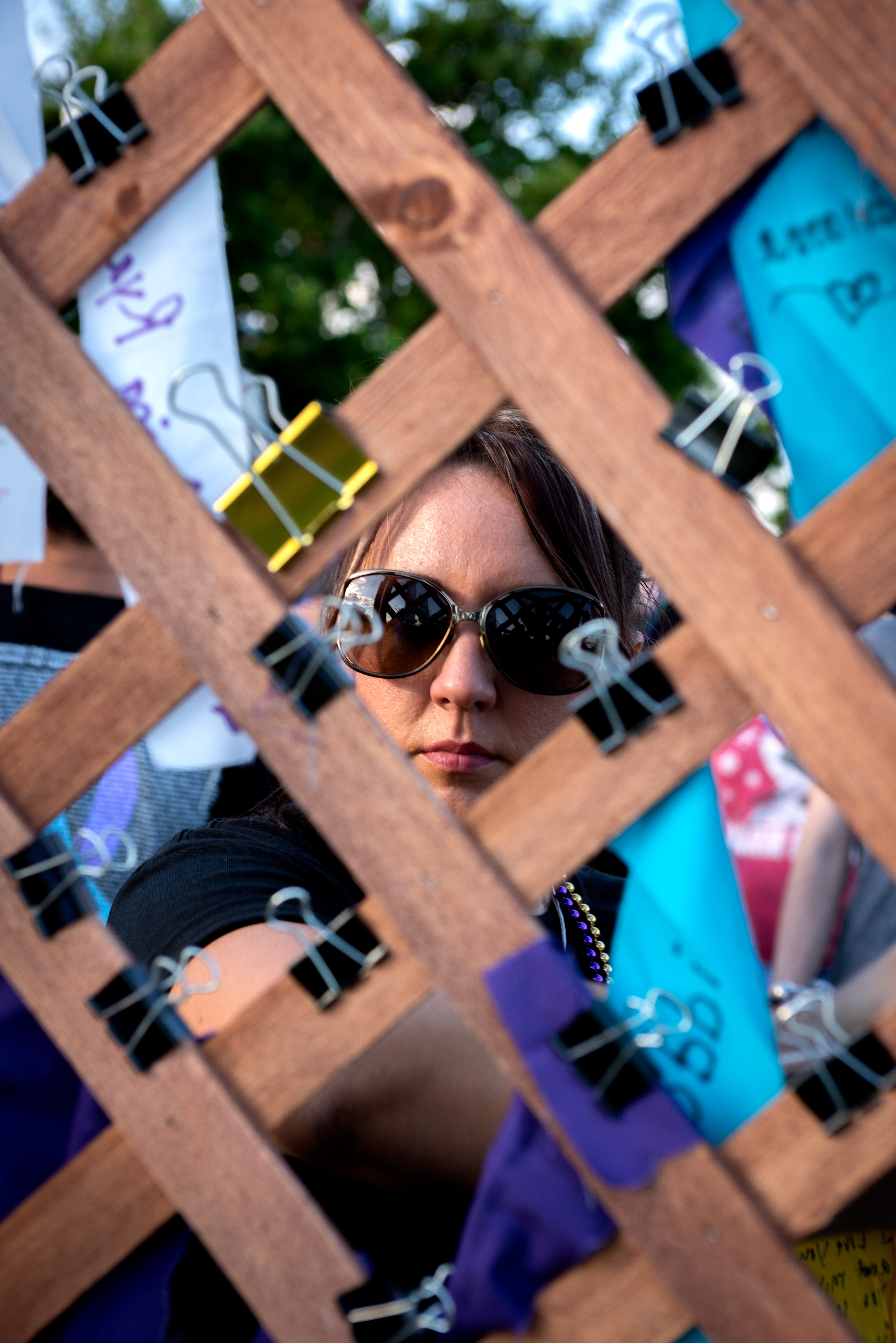 A woman places a ribbon onto a trellis, on Suicide Prevention Day 2018, in memory of her mother, lost to suicide four months earlier.