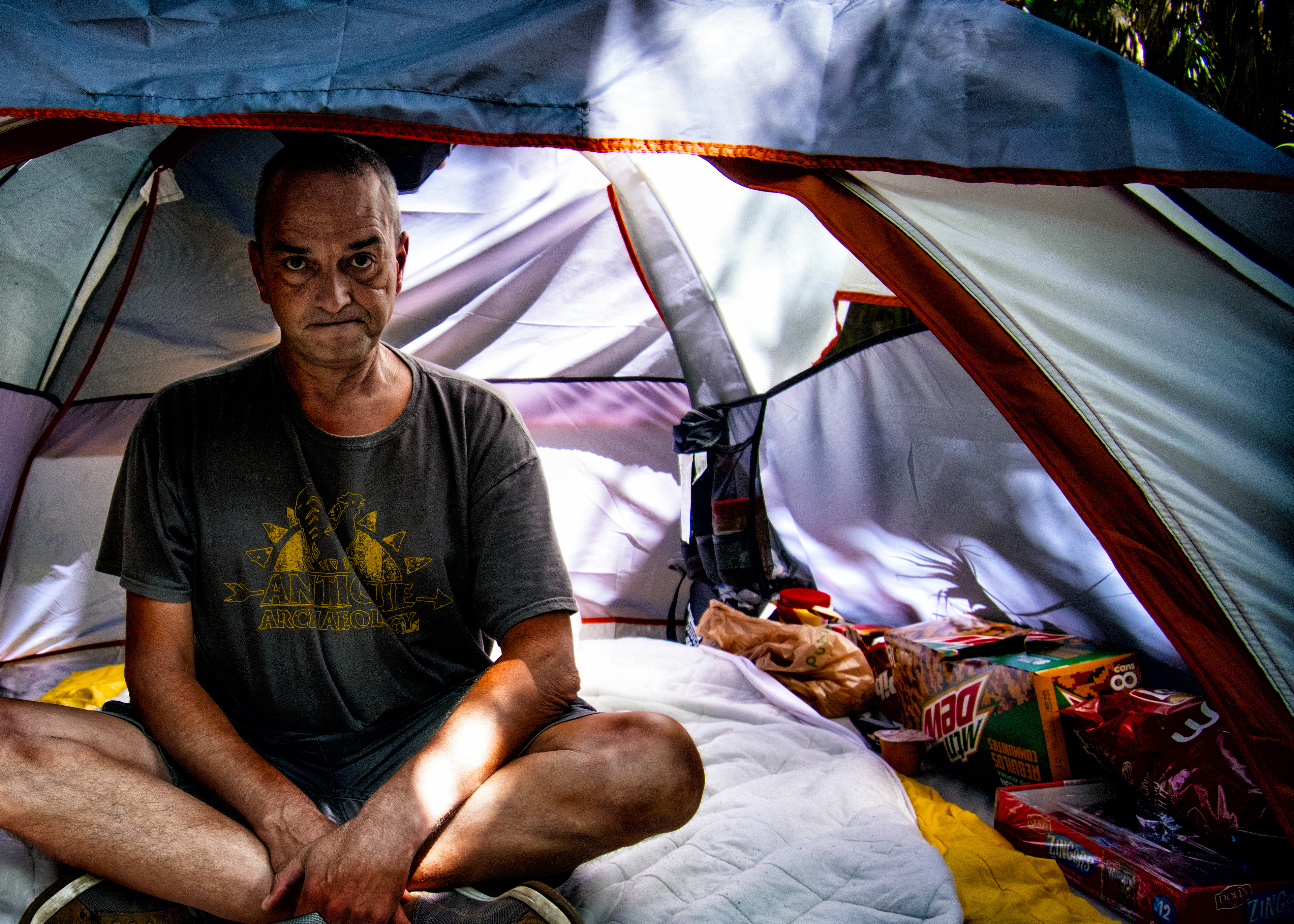 A homeless man sits in his tent, at a heavily wooded area of Charlotte County Florida.  