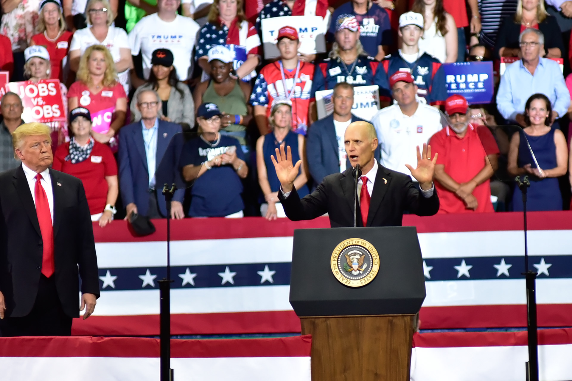 Florida Governor Rick Scott gestures to a capacity crowd, as President Donald Trump observes, during a rally in Estero Florida, on Wednesday, Oct 31, 2018.  Scott is running for U.S. Senate against Bill Nelson.
