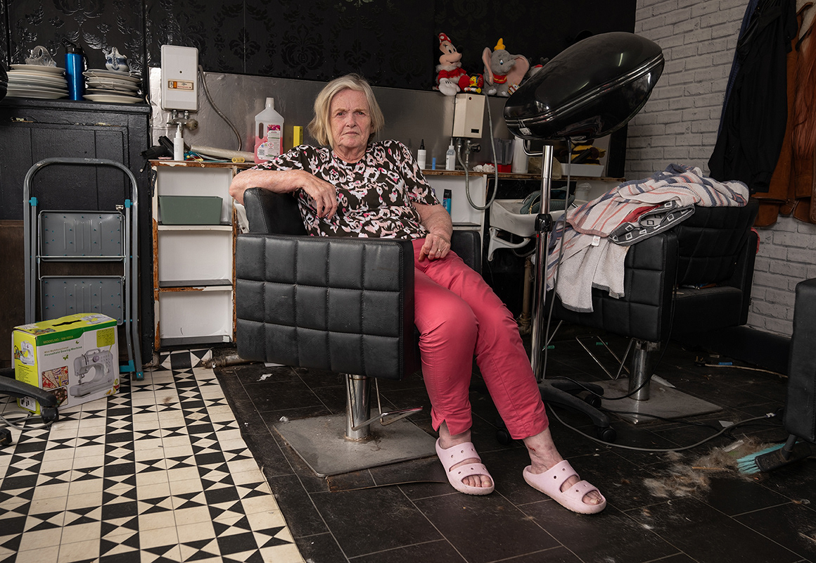 Glynis (2025) - Glynis pictured here on a break while clearing out her hair salon business, which she has had to retire from after 28 years of serving the Firswood community. Rent rises have forced her to close, and she has retired to Urmston. Firswood is an area in Old Trafford, Manchester.
