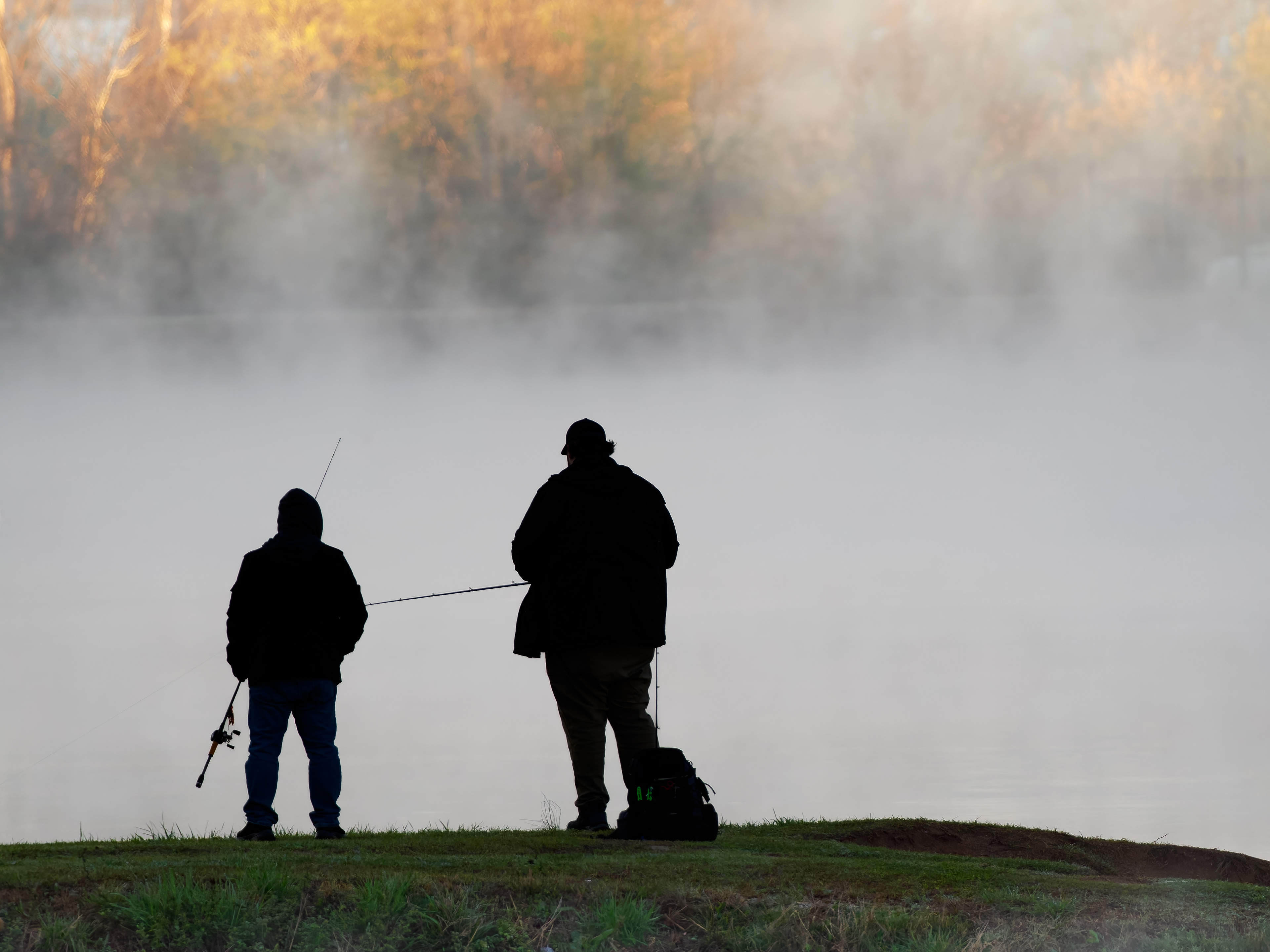 Man and boy fishing at sunrise.  Jefferson Lake in Jefferson Georgia.