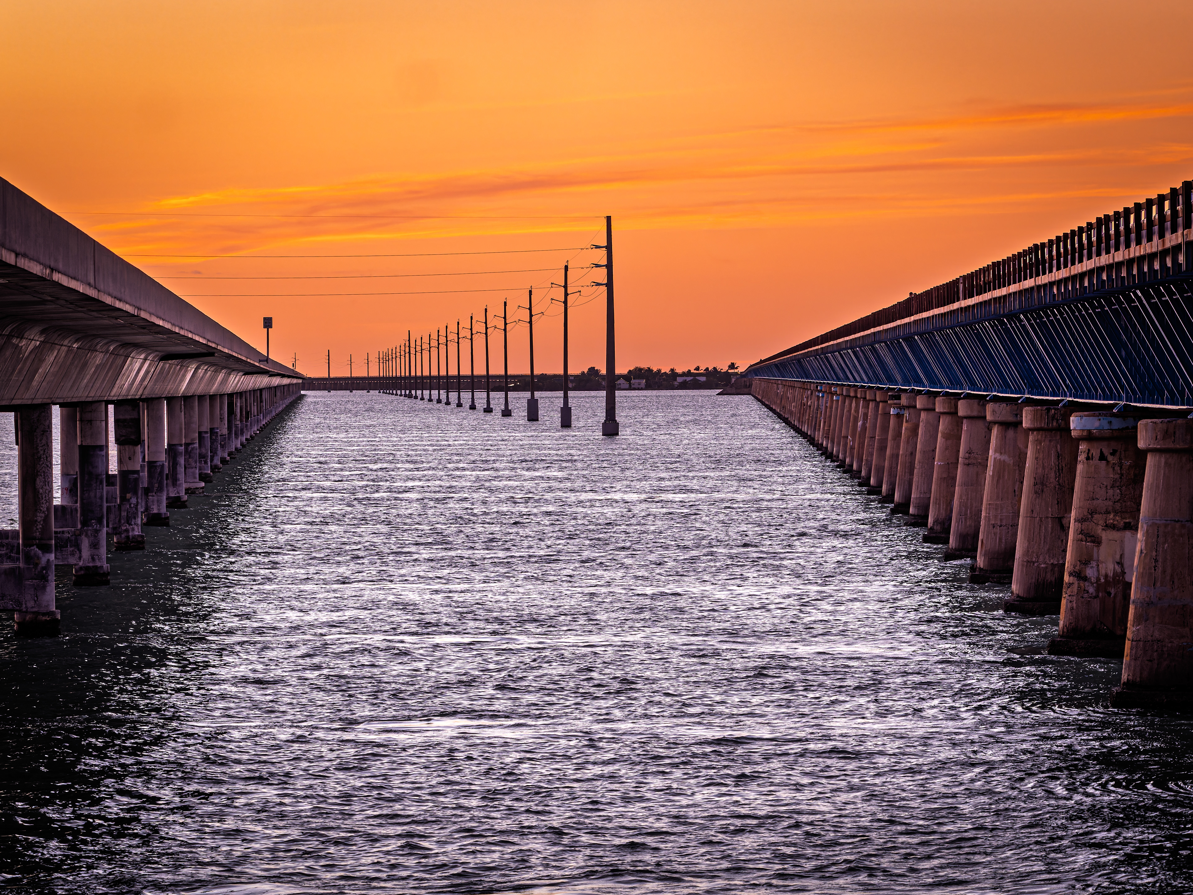 Sunset looking west with 7 mile bridge on left and remnants of old 7 mile bridge on right.   Florida Keys.