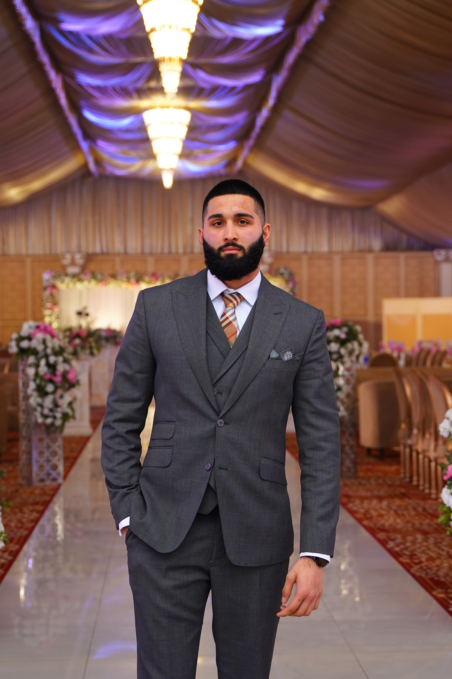 Muhammad Abbasi | Formal Wear | Charcoal three-piece suit with striped tie, hands at sides