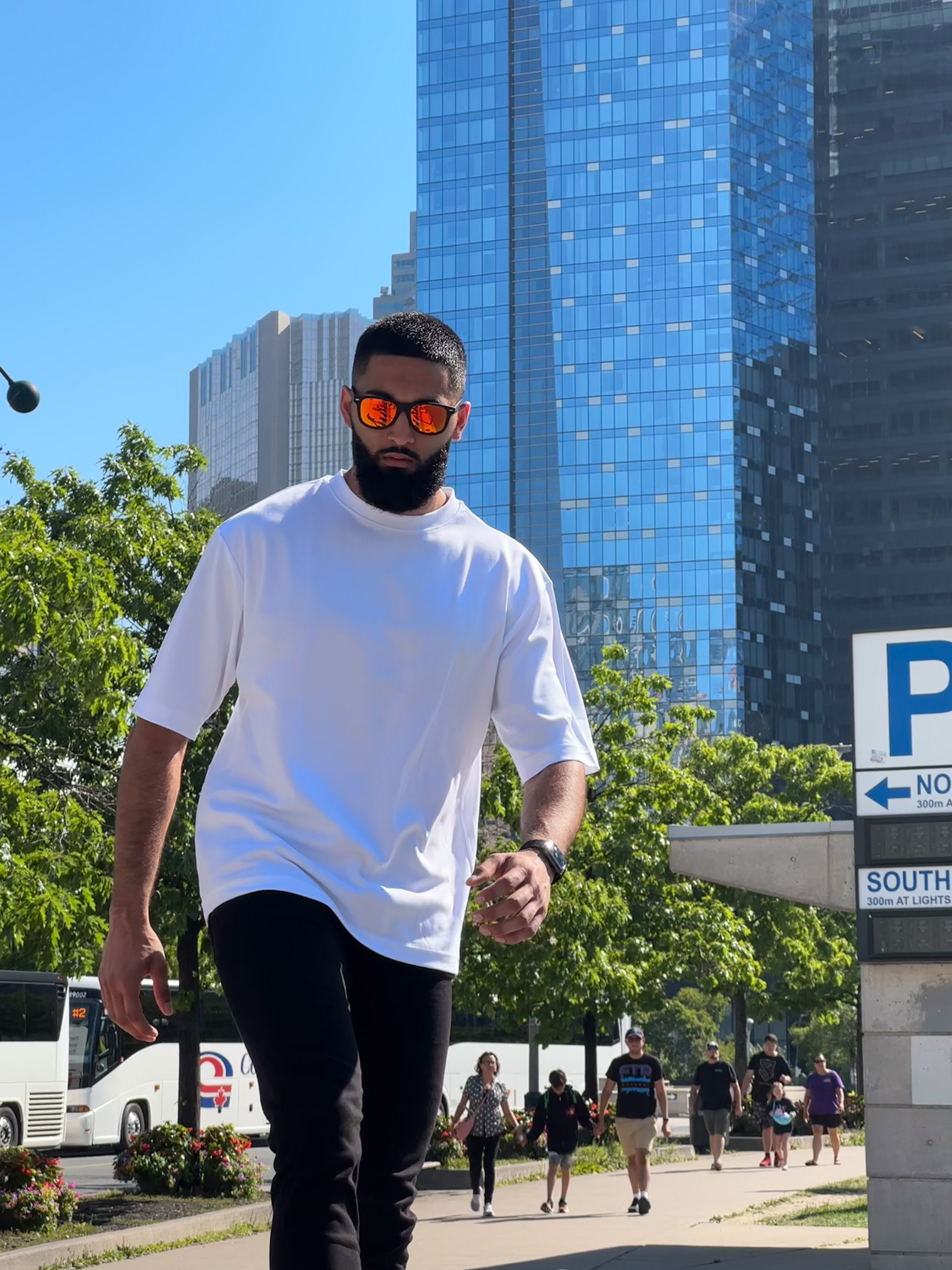 Muhammad Abbasi | Lifestyle | White oversized t-shirt, black jeans, colorful sneakers, close-up walking shot in Toronto