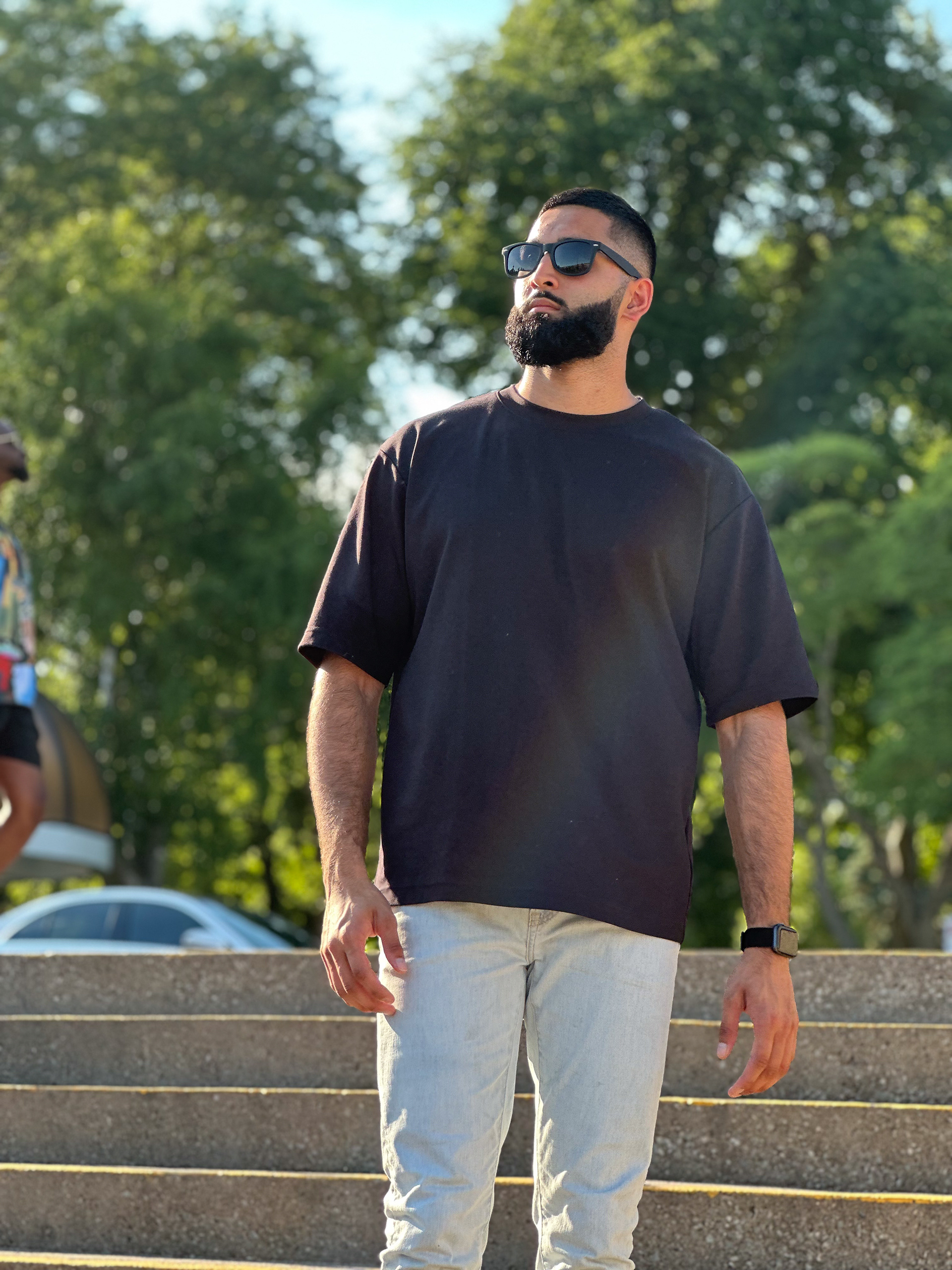 Muhammad Abbasi | Lifestyle | Black t-shirt, light blue jeans, black sneakers, front view walking down steps