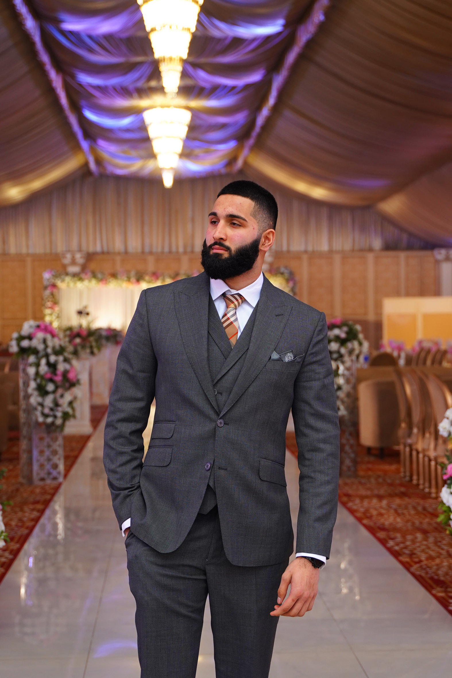 Muhammad Abbasi | Formal Wear | Charcoal three-piece suit with striped tie, hand in pocket