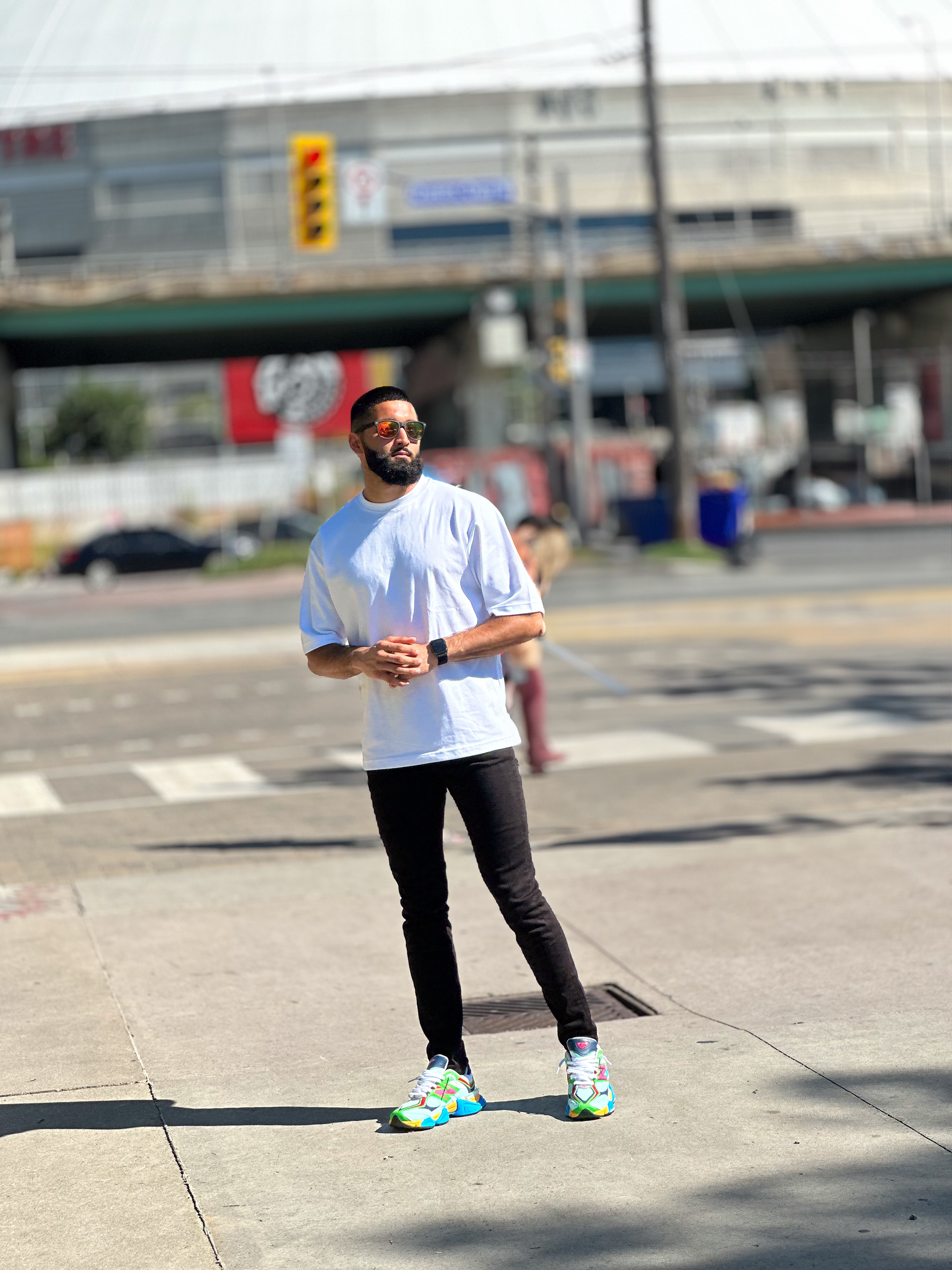 Muhammad Abbasi | Lifestyle | White oversized t-shirt, black jeans, colorful sneakers, casual pose near crosswalk