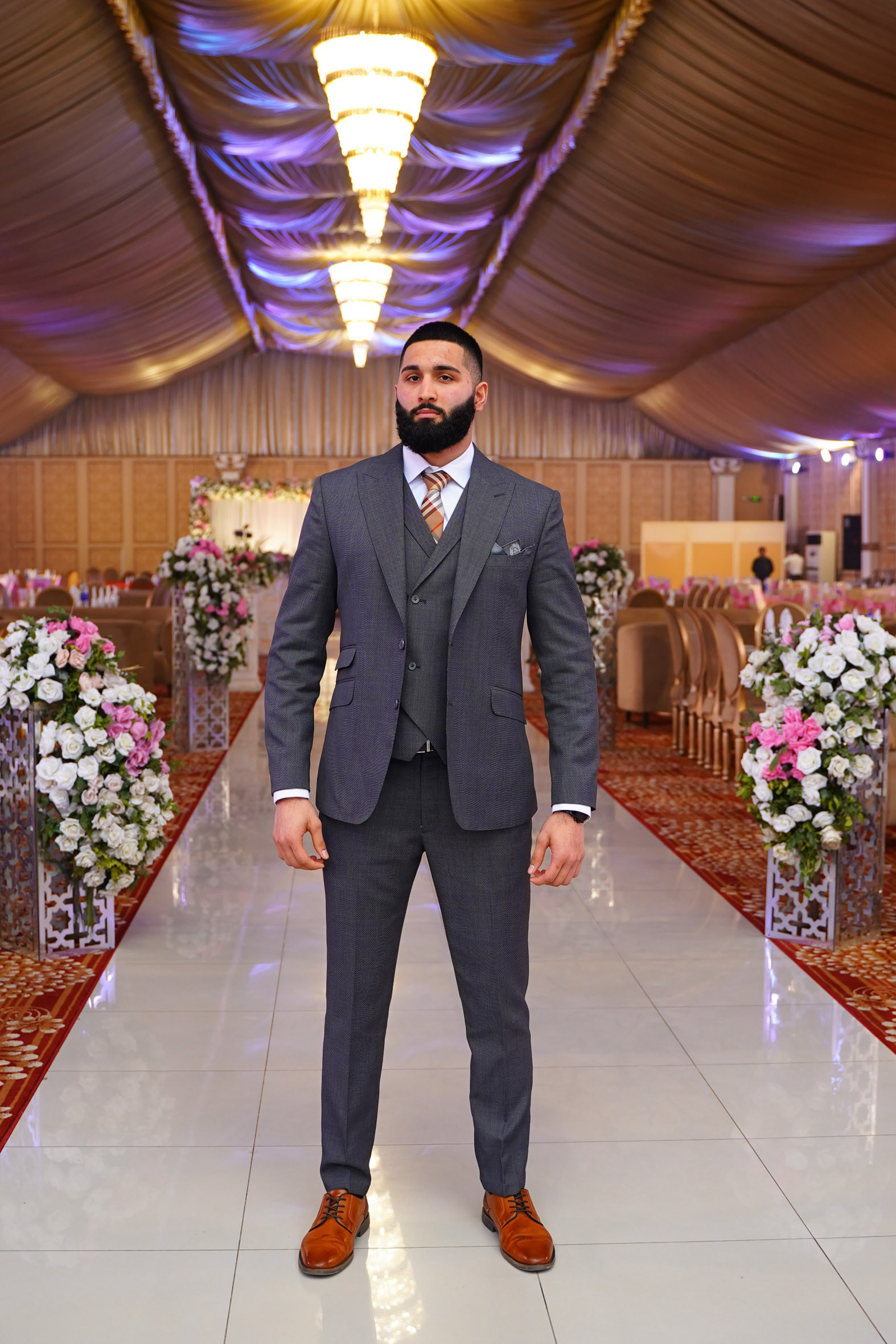 Muhammad Abbasi | Formal Wear | Charcoal three-piece suit with striped tie, standing straight facing forward