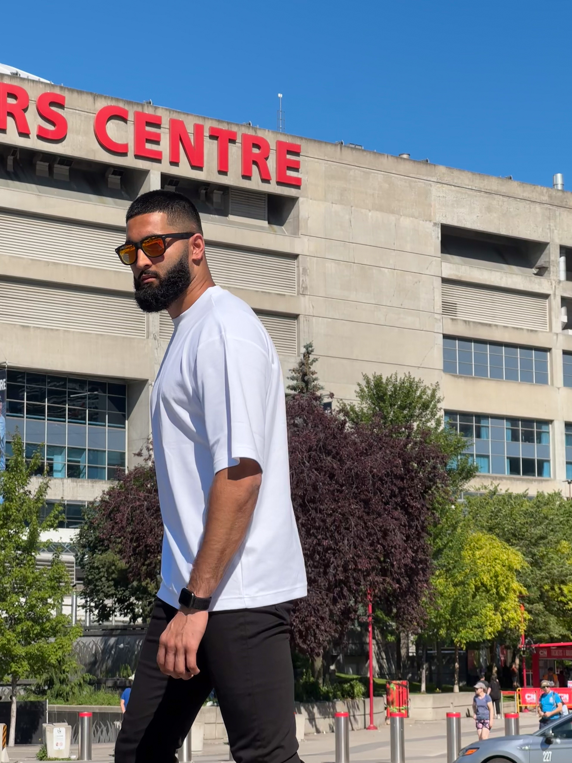 Muhammad Abbasi | Lifestyle | White oversized t-shirt, black jeans, colorful sneakers, candid walking near Rogers Centre